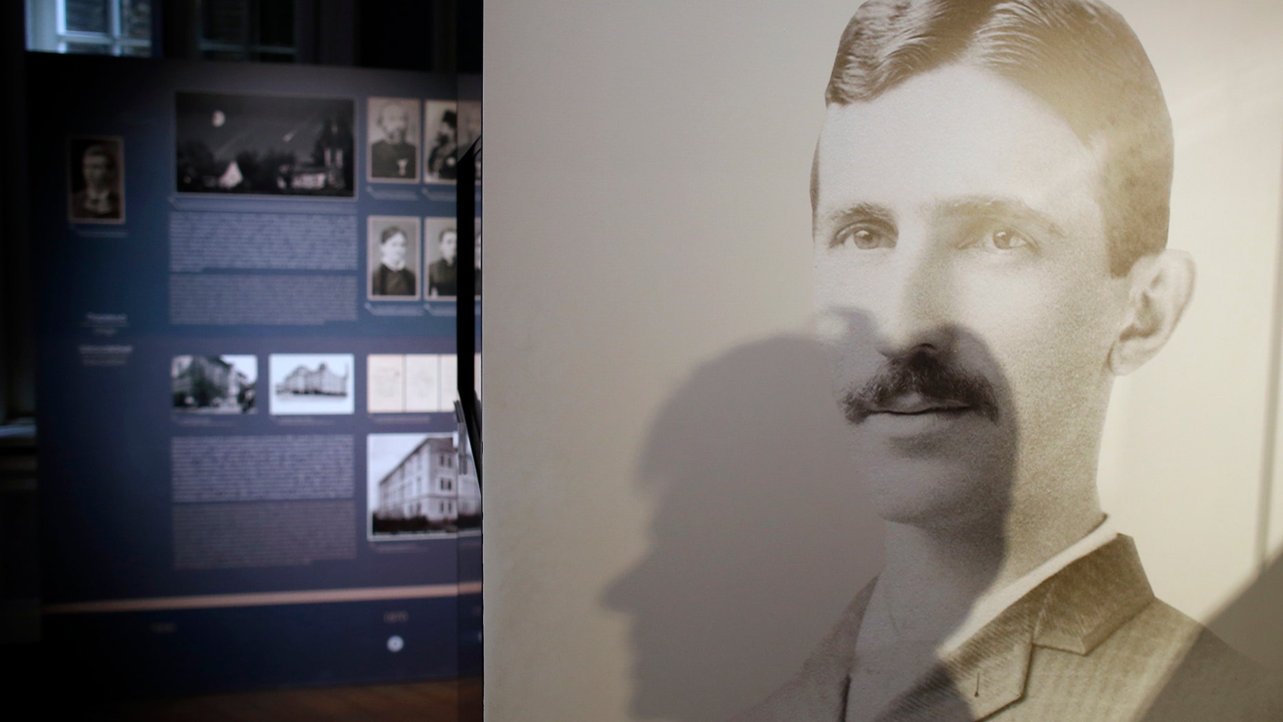 A shadow of Milica Kesler, curator and archivist is cast onto a poster of Nikola Tesla at the Nikola Tesla museum in Belgrade, Serbia, Thursday, March 7, 2019. A private culture society in Serbia has made public two letters written by Serb-American inventor and electricity pioneer Nikola Tesla. The Adligat group has told The Associated Press they recently obtained the letters from a collector and verified their authenticity with multiple sources. (AP Photo/Darko Vojinovic)