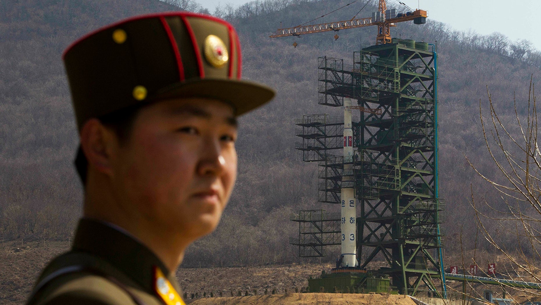 FILE - In this April 8, 2012, file photo, a soldier stands in front of the Unha-3 rocket at a launching site in Tongchang-ri, North Korea. (AP Photo/David Guttenfelder, File)