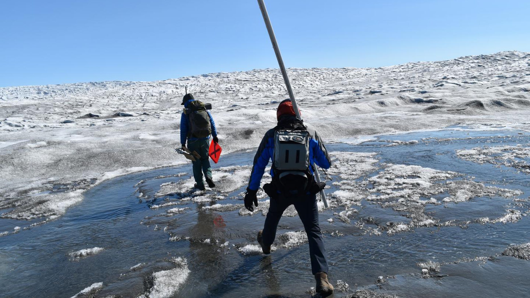 Increasing rainfall over the Greenland ice sheet is driving rapid melting of the surface. Here, researchers cross Greenland's Russell Glacier, July 2018. (Credit: Kevin Krajick/Earth Institute)