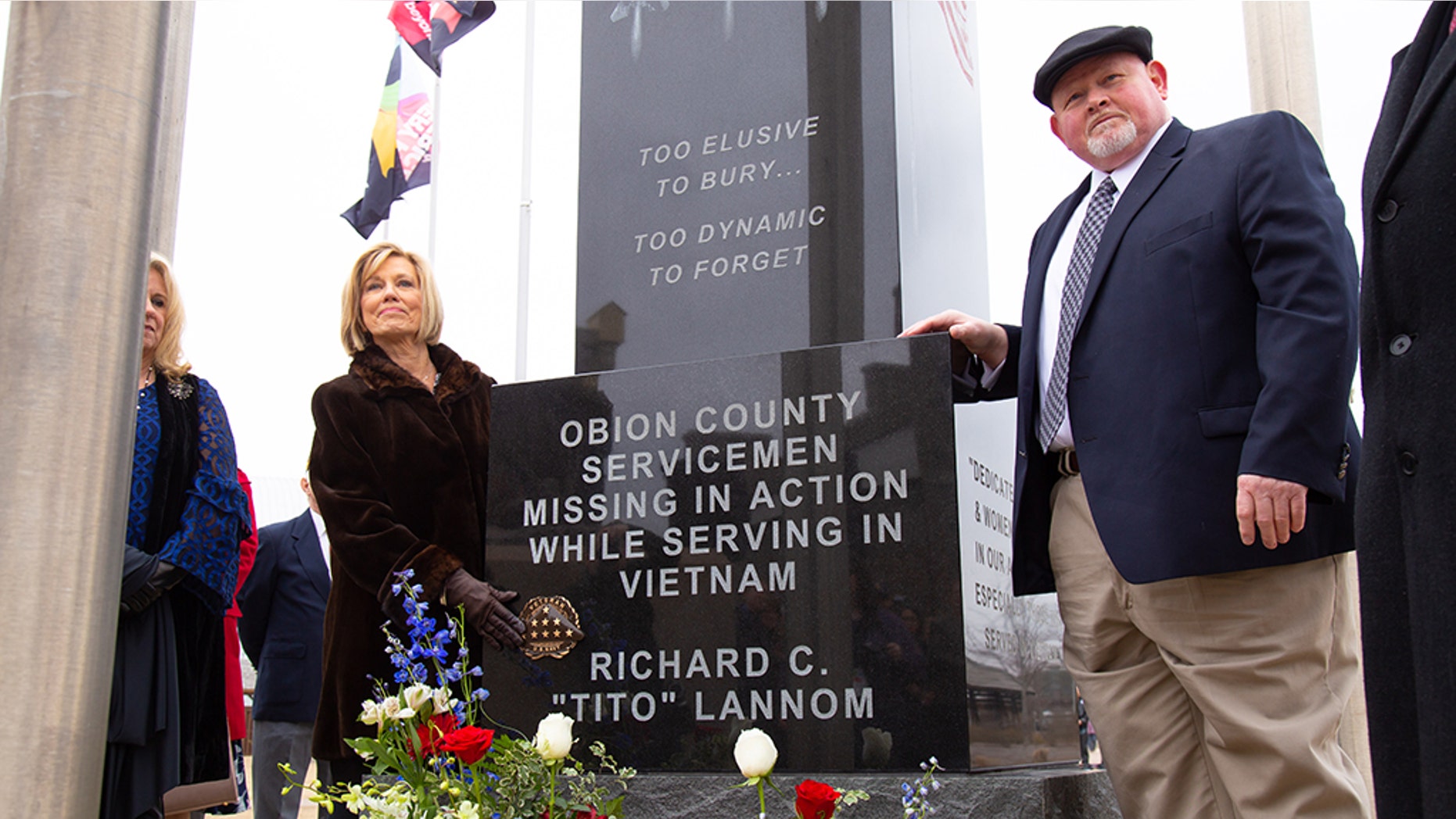 Lt. Richard "Tito" Lannom's widow Charlotte Shaw placed a rosette on the Vietnam Memorial next to her husband's name during memorial service at Discovery Park of America in Tennessee Saturday.