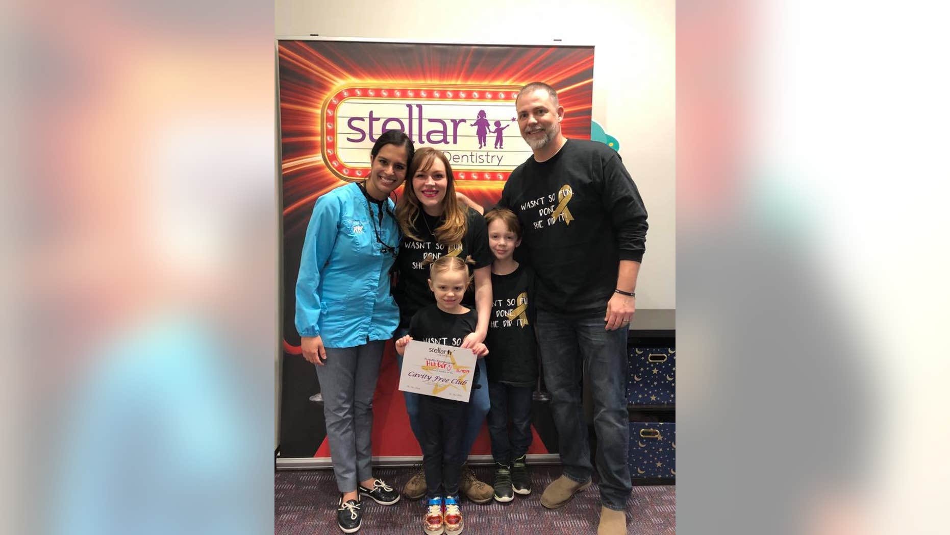 Hunter Jones, pictured holding her certificate, is now cancer-free after Dr. Harlyn Susarla, left, ordered a panoramic X-ray which revealed a growing tumor, and set-off 18 months of intense treatment to beat an aggressive cancer.