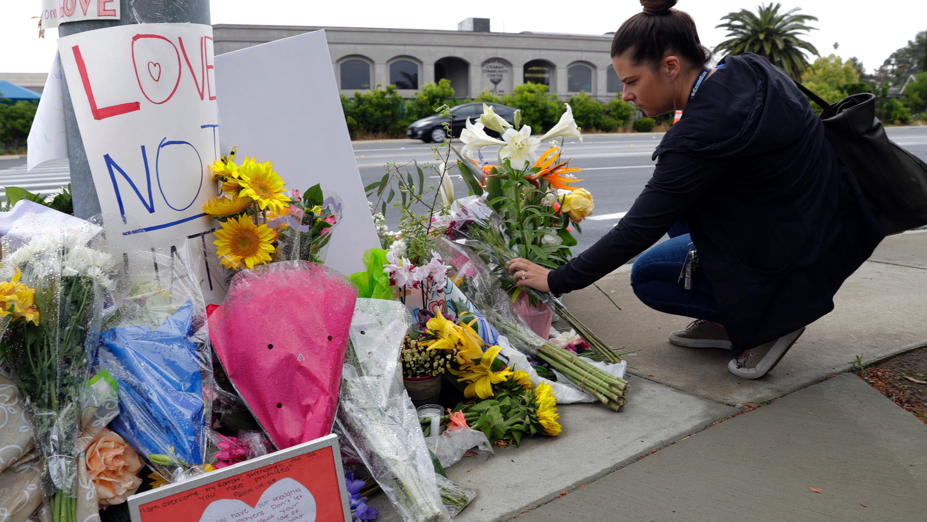 A woman leaves flowers on a growing memorial across the street from the Chabad of Poway synagogue in Poway, Calif., on Monday, April 29, 2019. (Associated Press)