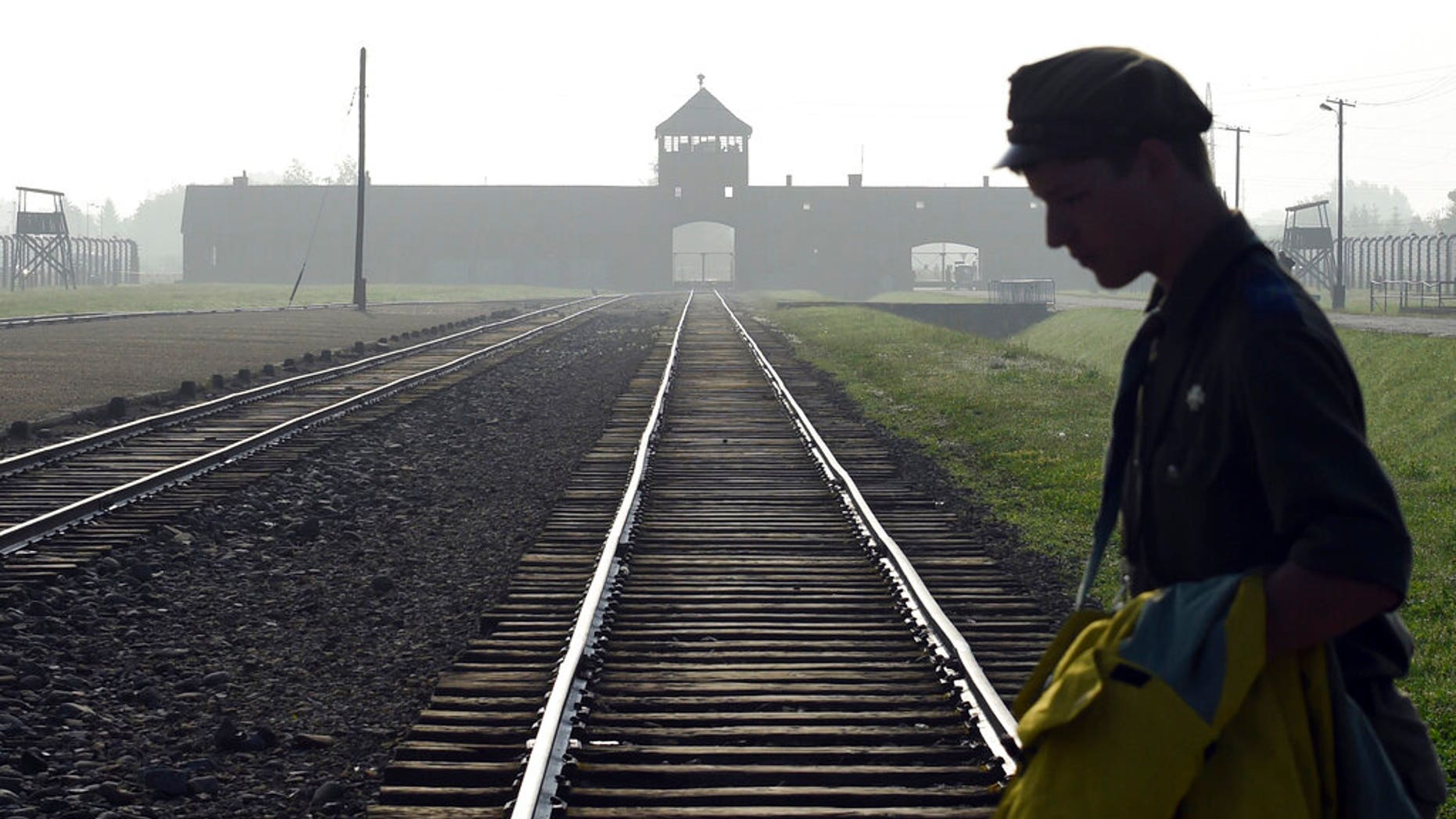 FILE: a man crosses the iconic rails leading to the former Nazi death camp of Auschwitz-Birkenau in Poland.