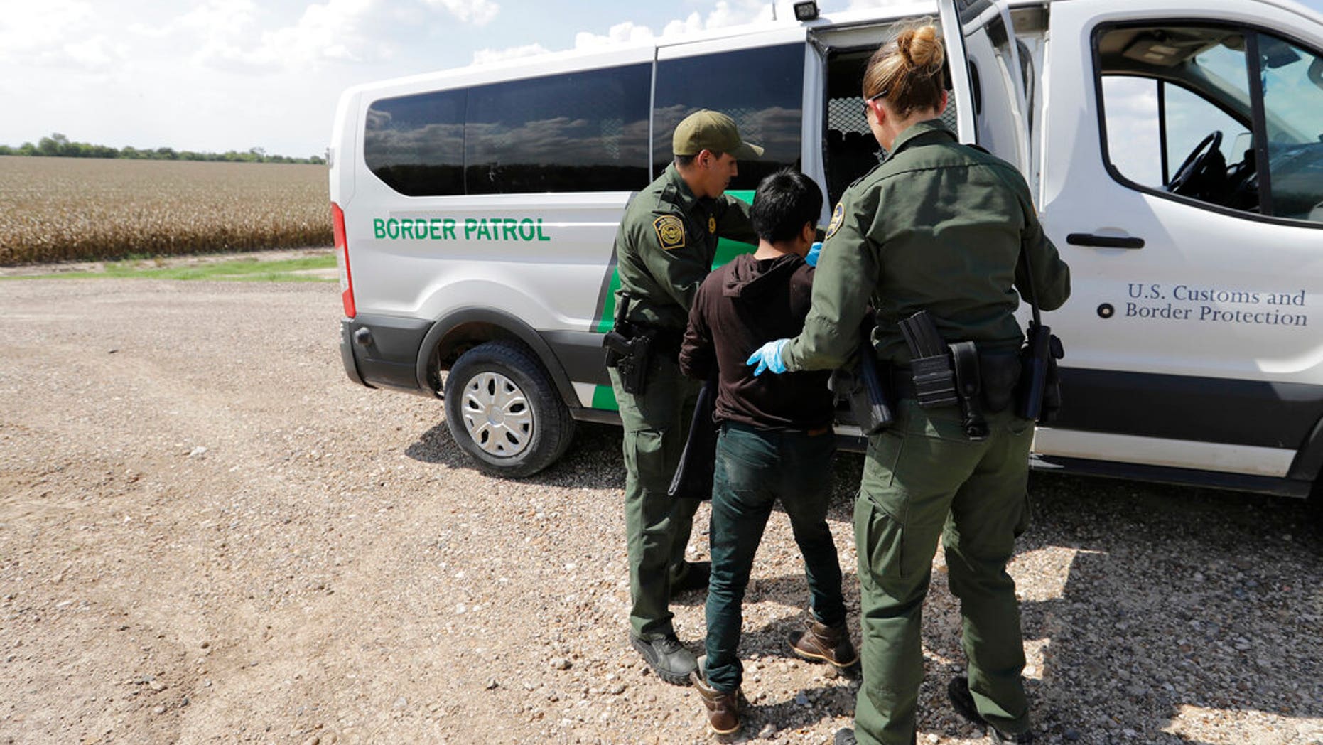 FILE: U.S. Border Patrol agents load a migrant from Guatemala into a van after he was caught trying to enter the United States illegally in Hidalgo, Texas. Â