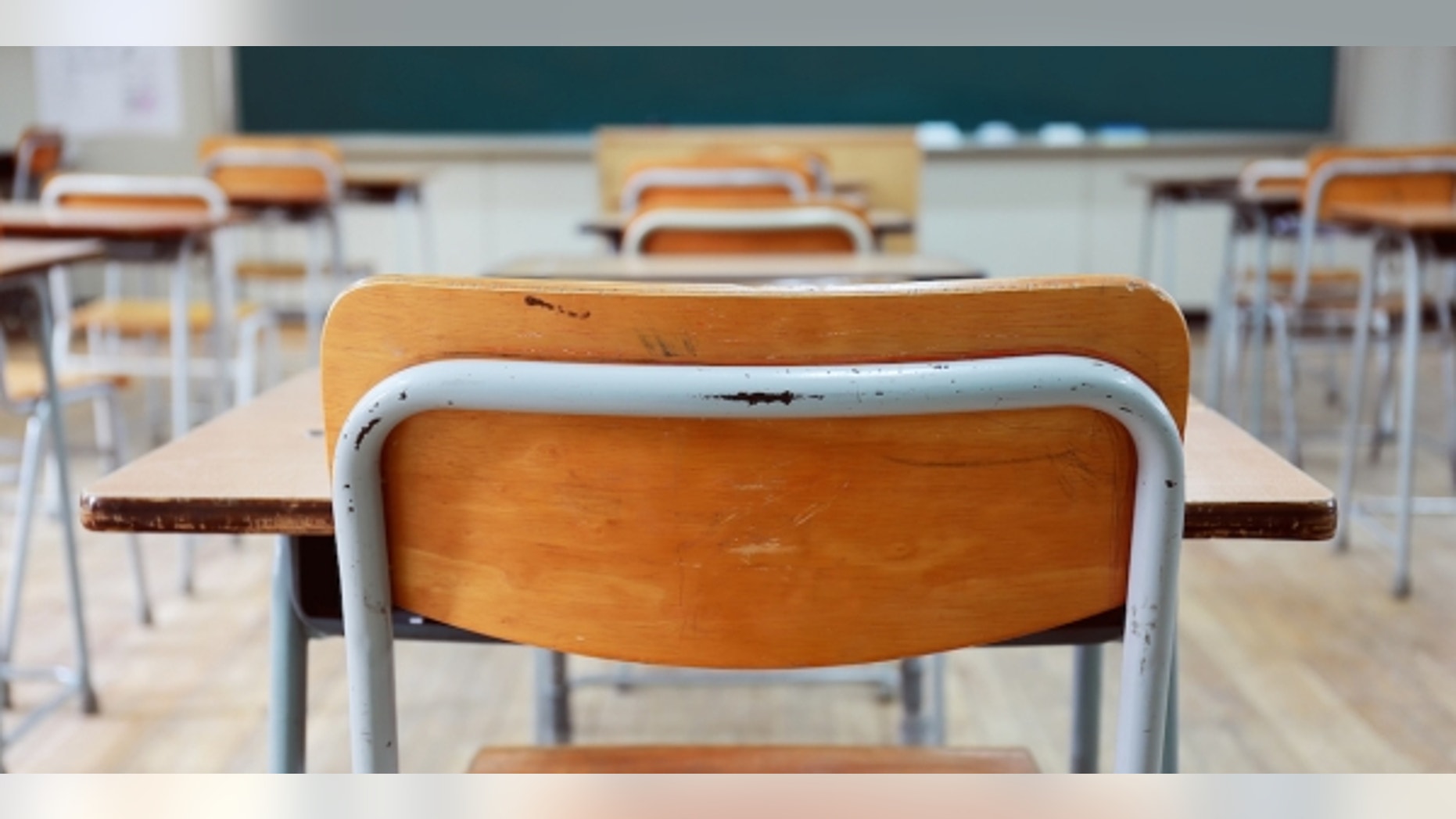 A Long Island teacher who was fired last week for a 3-year-old topless selfie threatens to sue his former school area unless it gives her a job back.