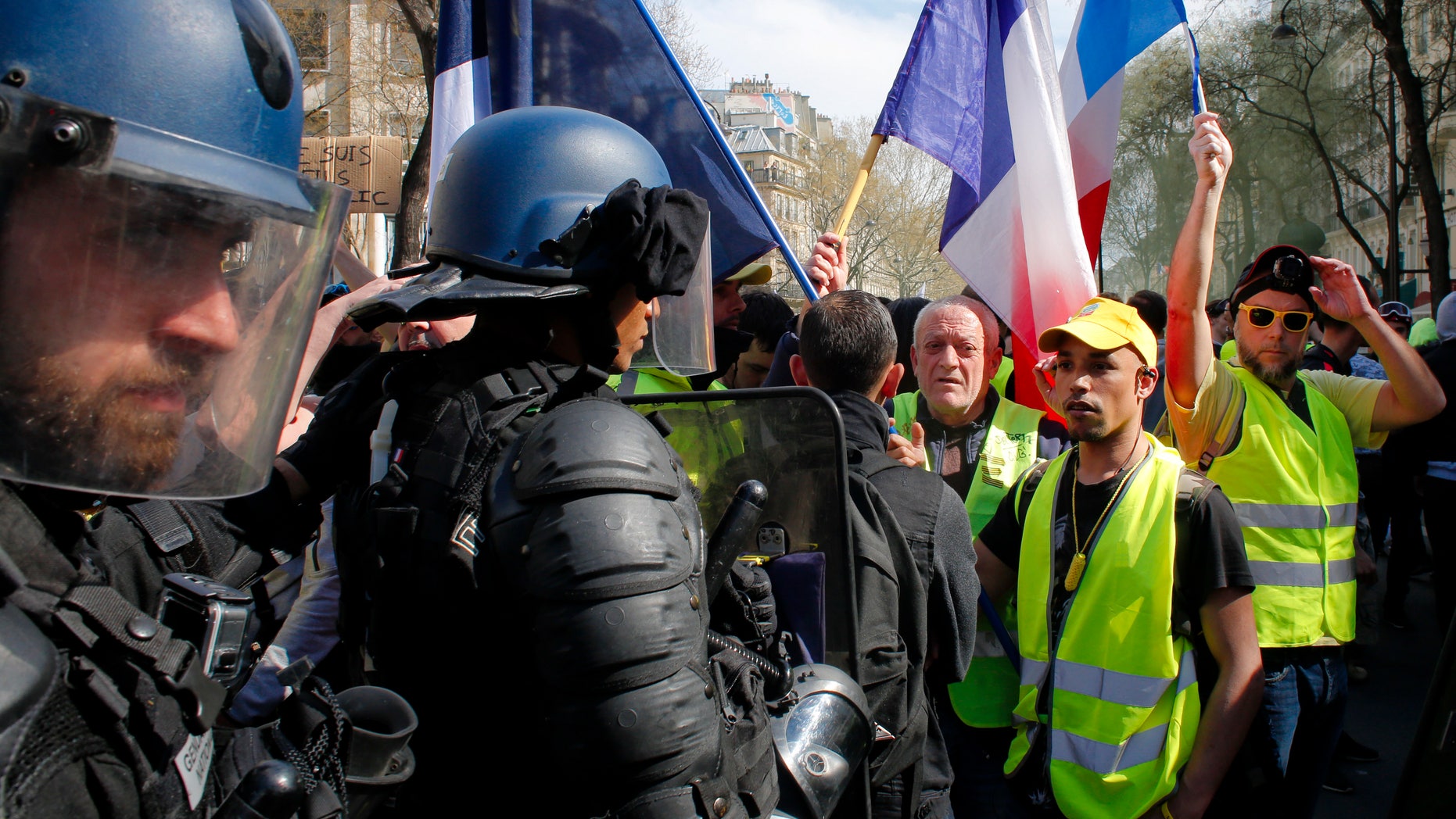 Riot policeman stand by as French yellow vest protesters are rallying to support an older woman activist injured in a confrontation with police, Saturday, March 30, 2019 in Paris. In 2019, 24 police officers in France have committed suicide, raising alarm over increased demand on the nation's police force.