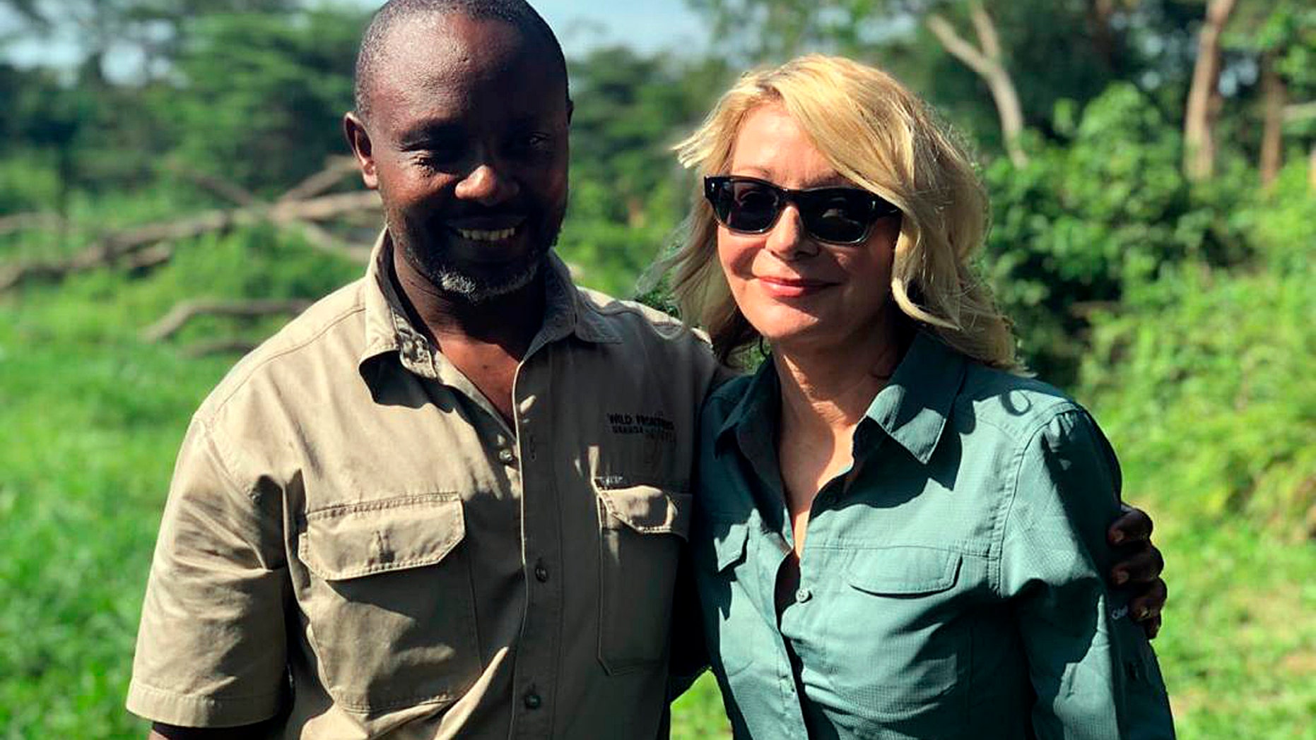Image released by Wild Frontiers tour company on Monday April 8, 2019, shows American tourist Kim Endicott, right, and field guide Jean-Paul Mirenge a day after they were rescued following a kidnap by unknown gunmen in Uganda's Queen Elizabeth National Park. Ugandan police said on Sunday they had rescued Endicott, an American tourist, and her guide, Mirenge, who had been kidnapped by gunmen in a national park. (Wild Frontiers via AP)
