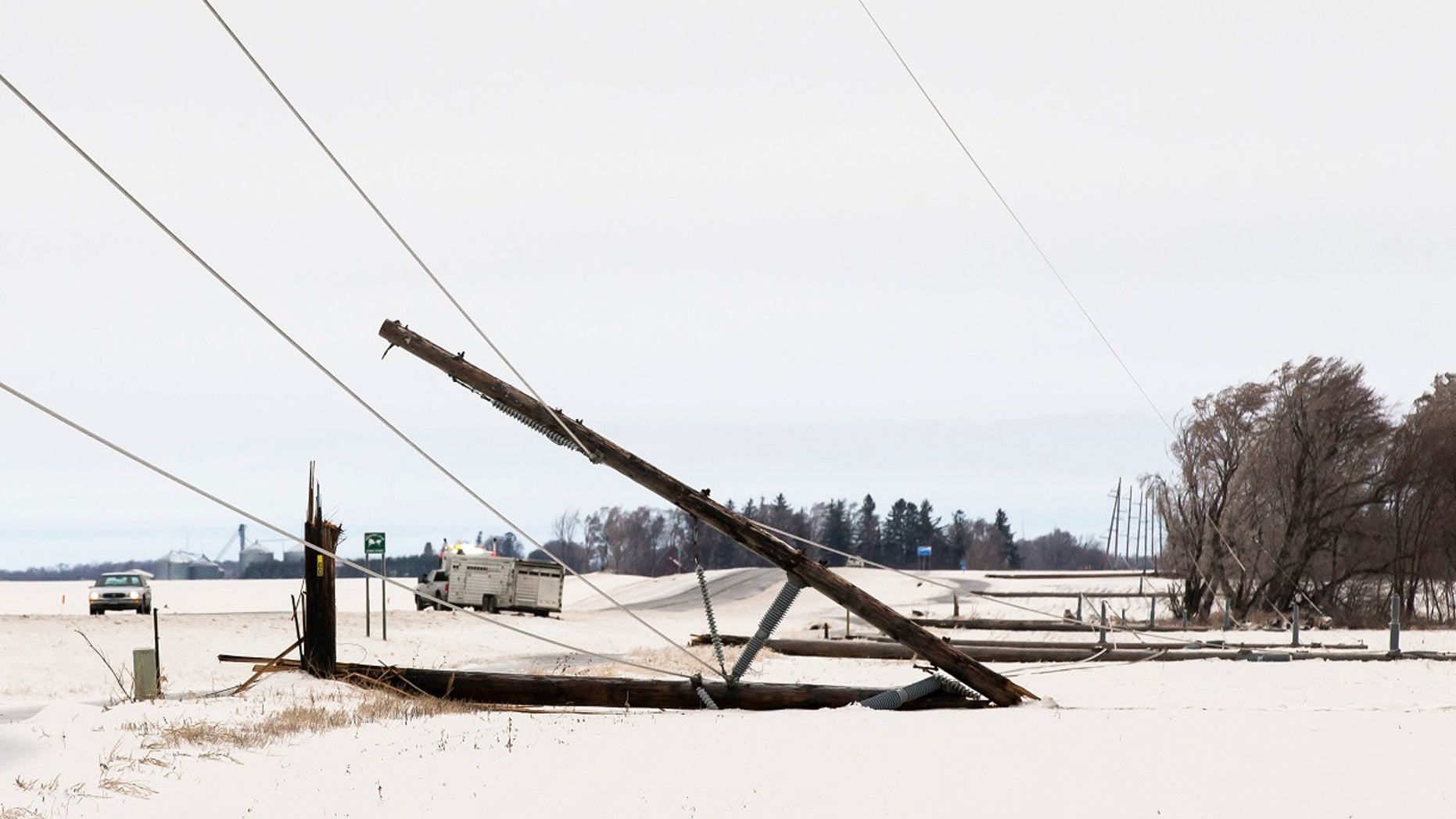 A row of power line poles are snapped from ice and wind along Hwy. 56 south of Interstate 90 on Thursday, April 11, 2019, near Browndale, Minn. A powerful spring snow storm is creating hazardous travel conditions in parts of the Midwest and Great Lakes regions. (Andrew Link/The Rochester Post-Bulletin via AP)