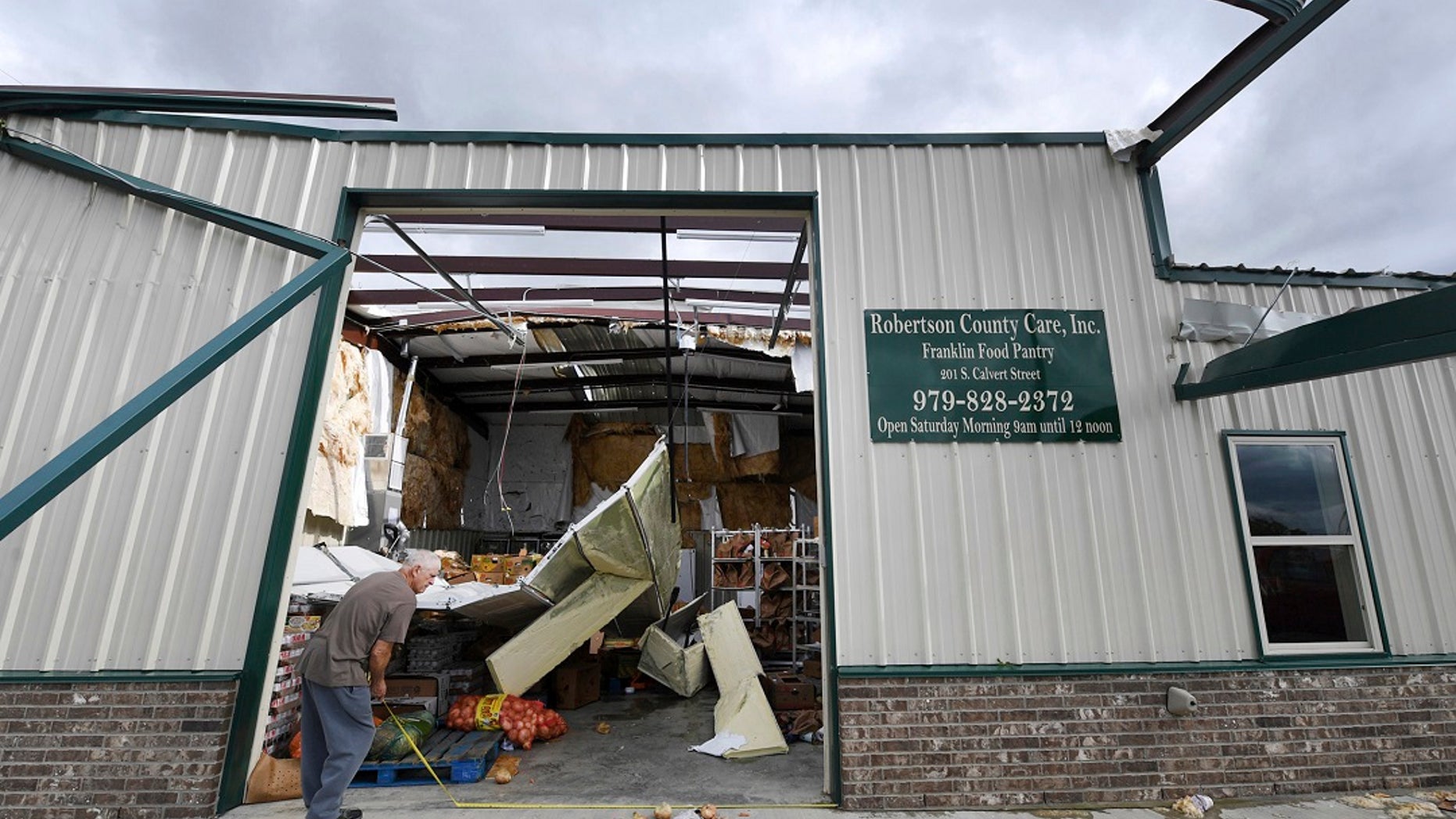 Jerry Redden takes a step outside of Robertson County Care, Inc., after the pantry was hit by a violent storm on Saturday in Franklin, Texas. (Associated Press)