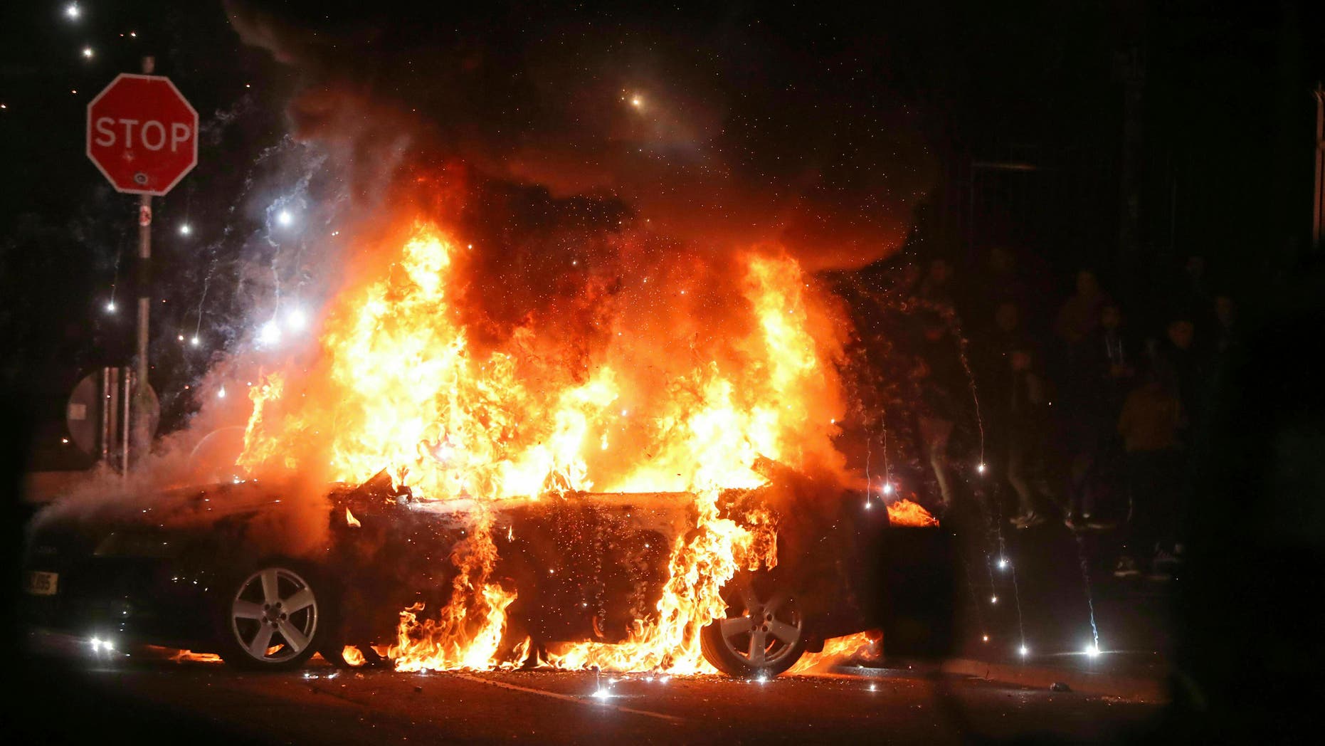 A journalist was shot to death during Northern Ireland rioting, Thursday, April 18, 2019. A car burns after petrol bombs were thrown at police in the Creggan area of Londonderry.