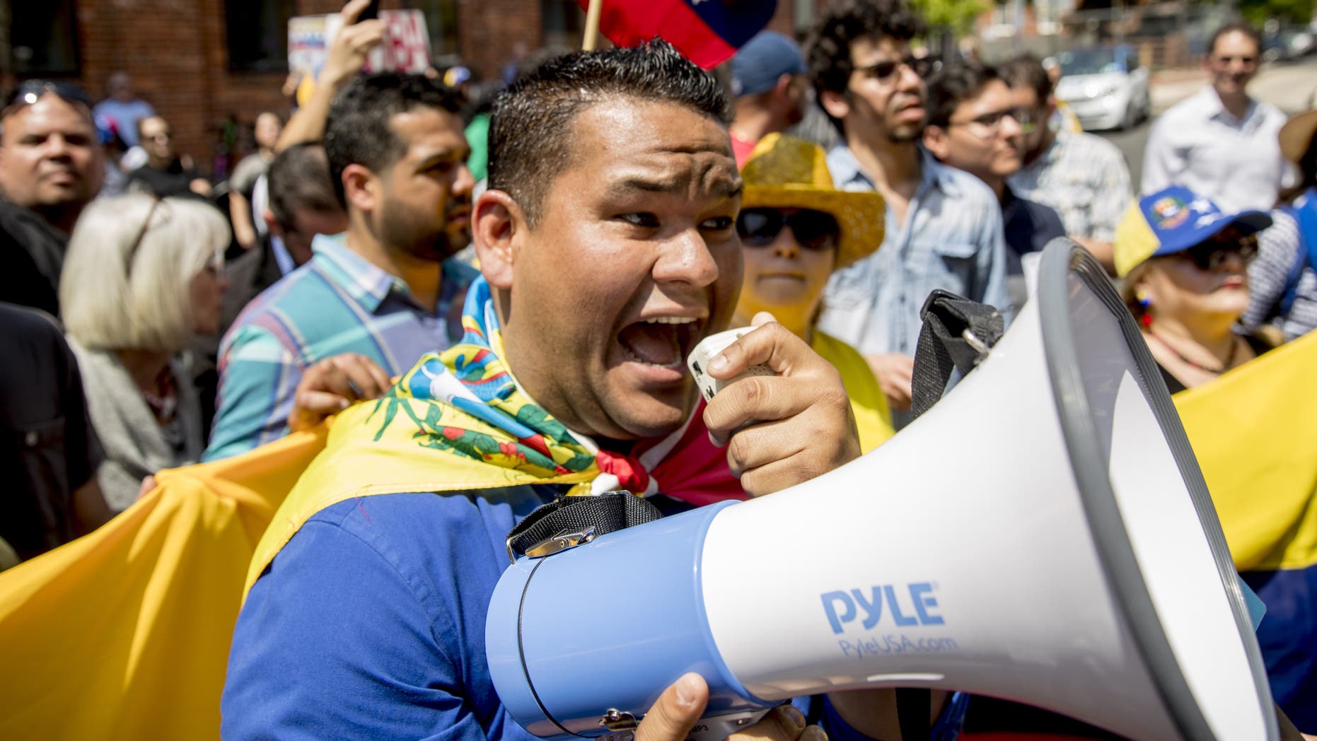 Supporters of interim government opposition leader Juan Guaido yell chants toward pro-Nicolas Maduro supporters as they rally outside of the Venezuelan Embassy in Washington, Tuesday, April 30, 2019. (AP Photo/Andrew Harnik)