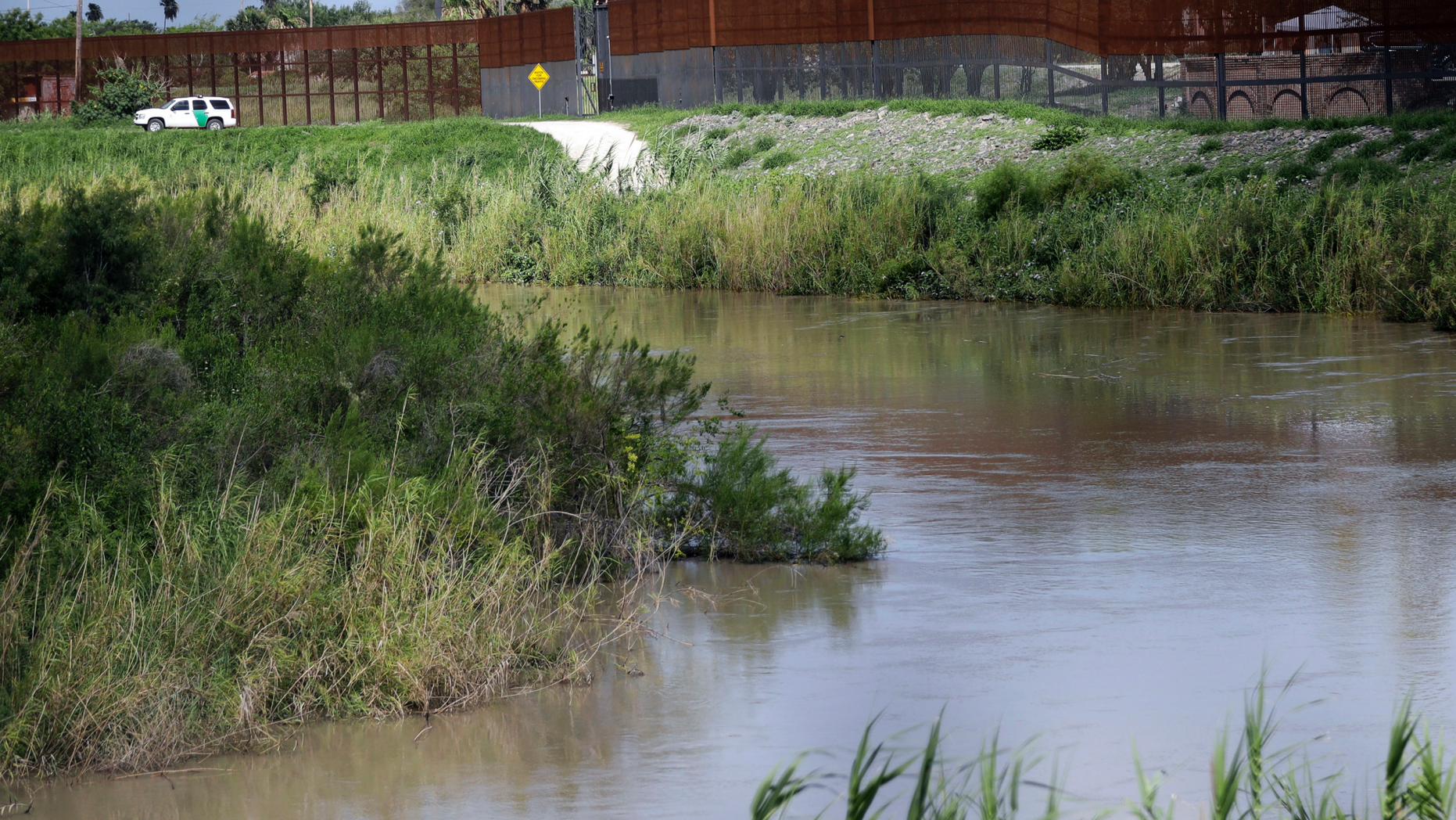 FILE - In this June 26, 2018, file photo, a U.S. Border Patrol vehicle sits above the Rio Grande River at the U.S. - Mexico border in Brownsville, Texas. U.S. Border Patrol agents found a 3-year-old boy alone in a field after likely being abandoned by smugglers at the southern border, authorities said. U.S. Customs and Border Protection said late Tuesday, April 23, 2019, that the boy's name and phone numbers were written on his shoes when agents found him that morning. The agency said it is trying to reach the boy's family. (AP Photo/David J. Phillip, File)