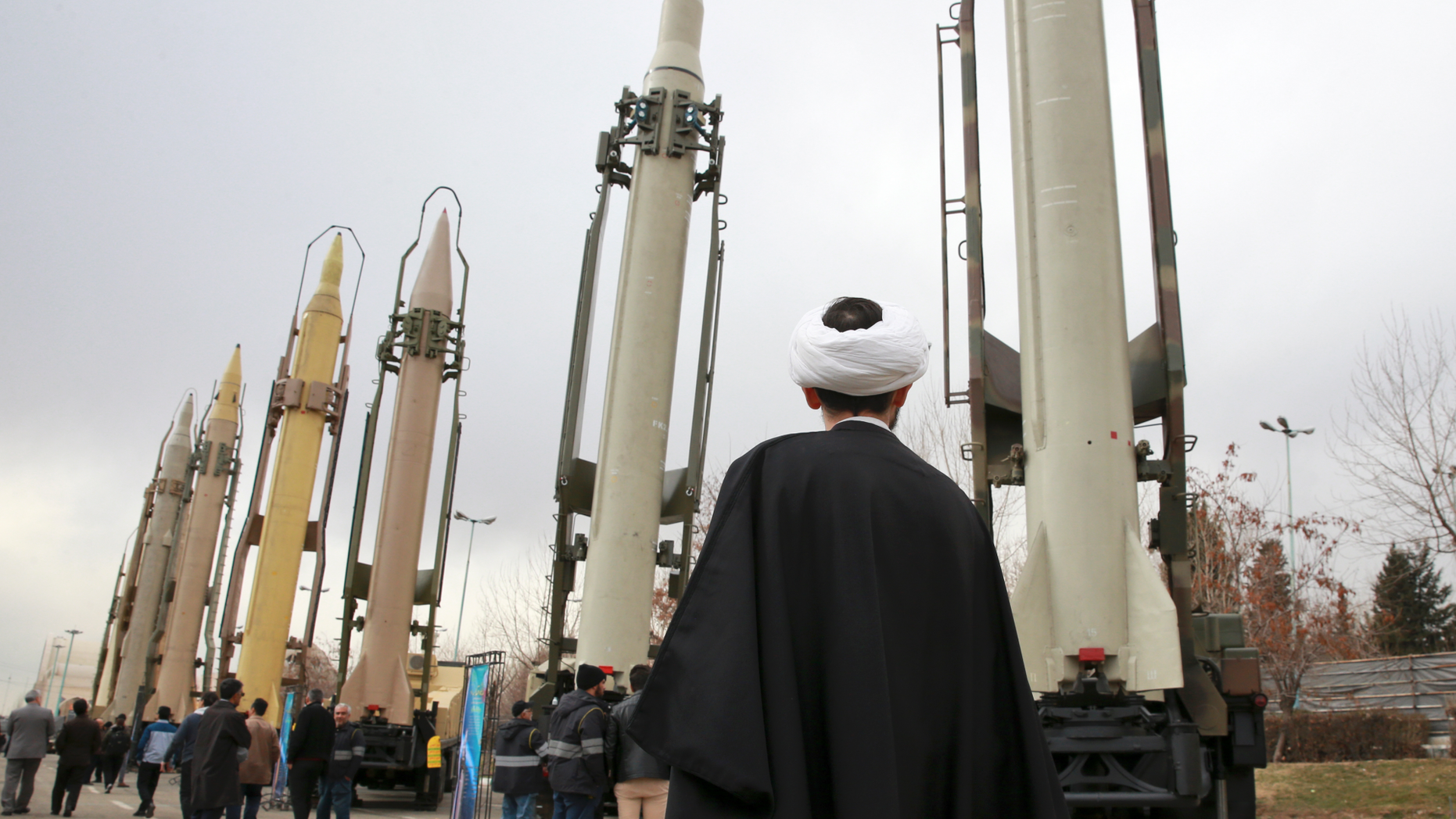FILE - In this Feb. 3, 2019 file photo, an Iranian clergyman looks at domestically built surface to surface missiles displayed by the Revolutionary Guard in a military show marking the 40th anniversary of the Islamic Revolution, at Imam Khomeini Grand Mosque in Tehran, Iran. On Monday, April 8, 2019, the Trump administration designated Iran’s Revolutionary Guard a “foreign terrorist organization” in an unprecedented move against a national armed force. Iran’s Revolutionary Guard Corps went from being a domestic security force with origins in the 1979 Islamic Revolution to a transnational fighting force. (AP Photo/Vahid Salemi, File)