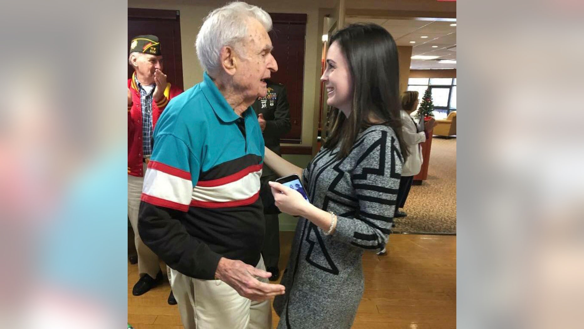 In this December 2017 photo provided by Beth Regan, Regan speaks to Robert Graham in Cortland, N.Y. The decorated World War II veteran who died in April 2017 with no living relatives is being honored thanks to an unlikely friendship with the young woman who is determined to give him a farewell befitting a hero. (AP Photo/Jim Regan)