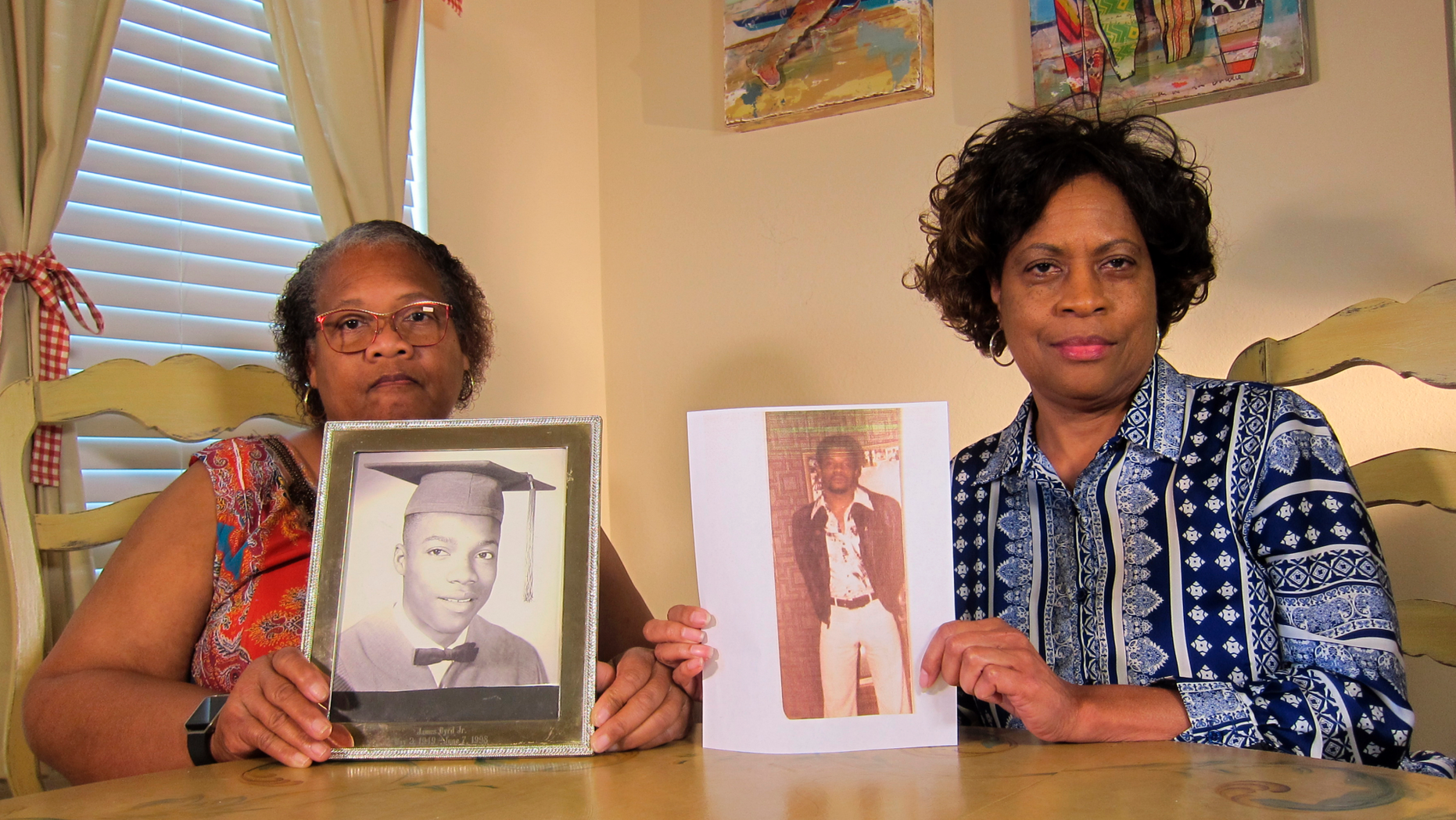 In this Wednesday, April 10, 2019, photo Mylinda Byrd Washington, 66, right, and Louvon Byrd Harris, 61, hold up photographs of their brother James Byrd Jr. in Houston. James Byrd Jr. was the victim of what is considered to be one of the most gruesome hate crime murders in recent Texas history. (AP Photo/Juan Lozano)