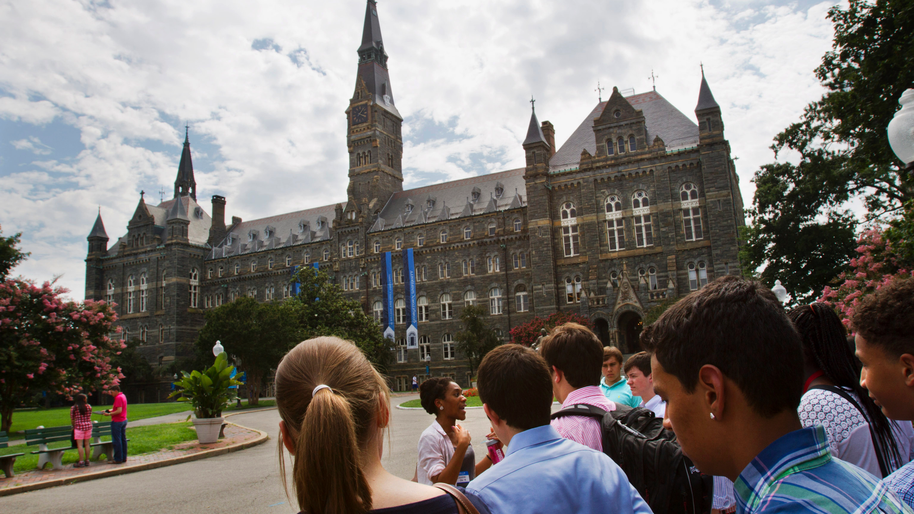 FILE - In this July 10, 2013, file photo, prospective students tour Georgetown University's campus in Washington. Georgetown University students are considering a fee benefiting the descendants of enslaved people sold to pay off the school’s debts, an effort that would create one of the first reparations funds at a major U.S. institution. Undergraduates will vote Thursday, April 11, 2019 on a $27.20-per-semester fee that would go toward underprivileged communities where some descendants live. (AP Photo/Jacquelyn Martin, File)