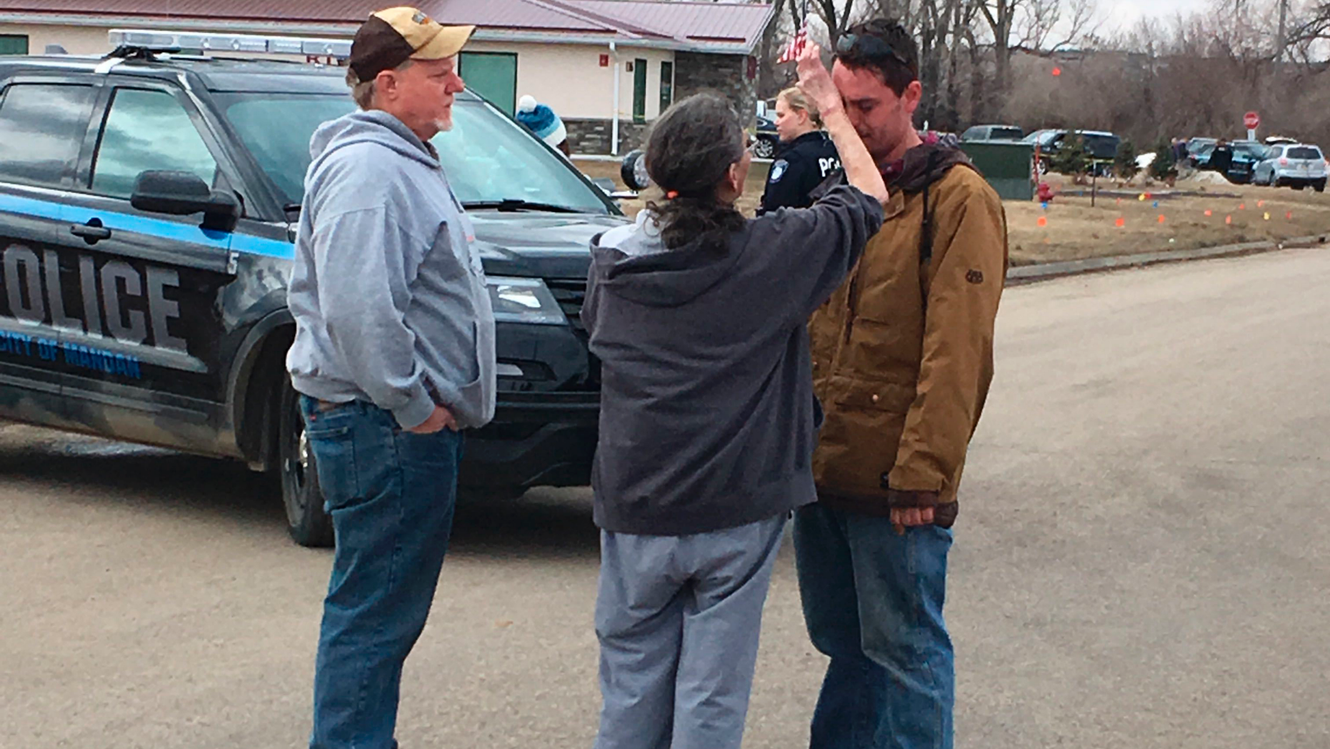 Gina Kessel, center, comforts her son Mitchell outside of RJR Maintenance and Management, a property management company, Monday, April 1, 2019, Mandan, N.D. Authorities say police responding to a medical call at the North Dakota business have found "several" bodies. The Mandan Police Department issued a three-sentence news release confirming that officers had found "several people who were deceased inside" the business in the city of about 22,000 just across the Missouri River west of Bismarck. (AP Photo/Blake Nicholson)