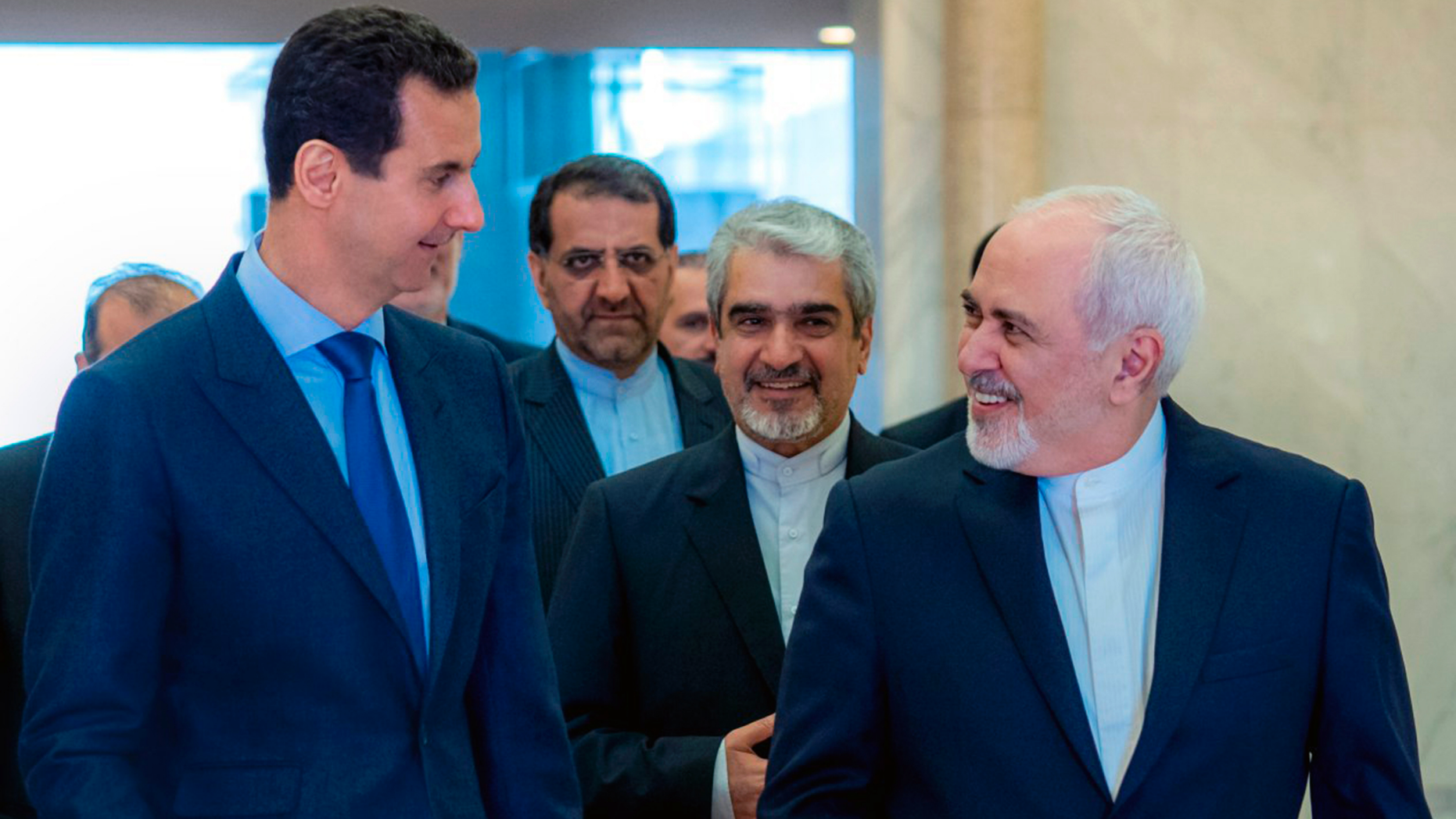This photo released on the official Facebook page of Syrian Presidency shows Syrian President Bashar Assad, left, speaking with Iranian Foreign Minister Mohammad Javad Zarif, right, in Damascus, Syria, Tuesday, April 16, 2019. Zarif has blasted upon arrival in Syria the Trump administration decision to designate Tehran's Revolutionary Guards Corps a terrorist organization calling it a "stupid act." (Syrian Presidency Facebook page via AP)
