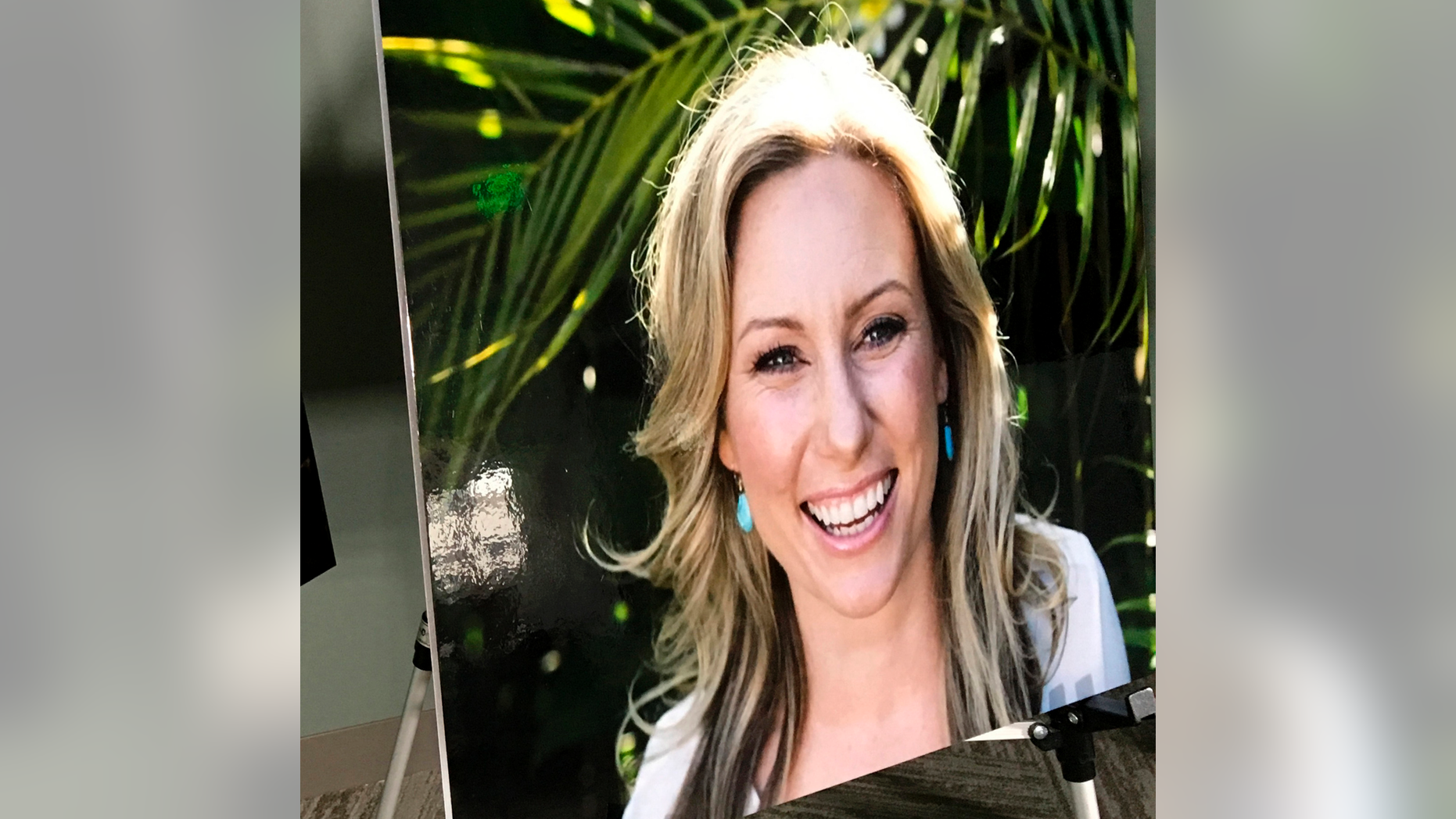 FILE - In this July 23, 2018, file photo, a poster of Justine Ruszczyk Damond is displayed at a news conference by attorneys for her family in Minneapolis. The Minneapolis woman who was fatally shot by a police officer in 2017 had spent a lifetime trying to help people and animals. Damond's relatives describe her as an animal lover who originally trained as a veterinary surgeon. (AP Photo/Amy Forliti, File)