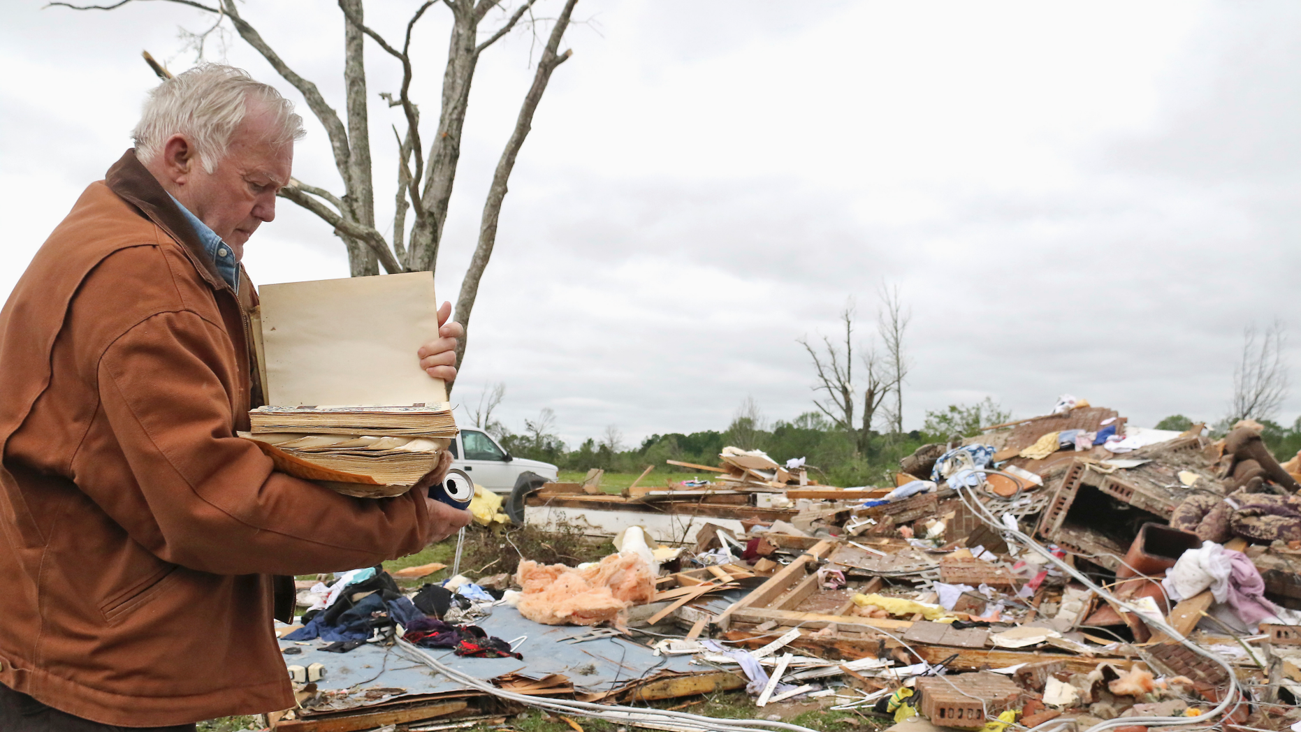 Robert Scott examines a family Bible that he just came out of the rubble on Sunday, April 14, 2019, from his home at Seely Drive, outside of Hamilton, Missouri, after An apparent tornado hit Saturday night, April 13, 2019. (AP Photo / Jim Lytle)