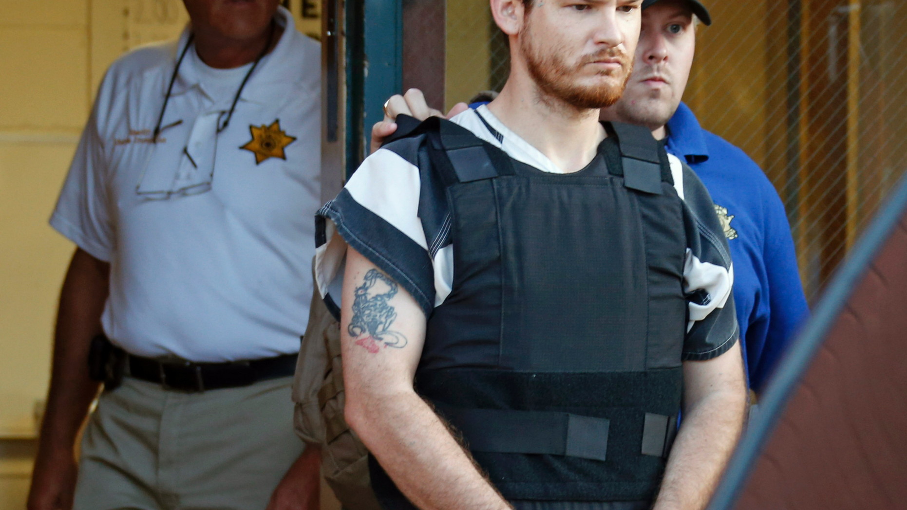 FILE - In this Thursday, Sept. 11, 2014 file photo,Smith County Sheriff Charlie Crumpton, left, watches as Timothy Ray Jones Jr., is escorted by lawmen out of the Smith County Jail to a vehicle for transport to Lexington County, S.C. in Raleigh, Miss. Jury selection is set to begin Monday, April 29, 2019 in the death penalty trial of Jones who police said killed his five young children in their South Carolina home. Authorities say after 37-year-old Timothy Jones Jr. killed his children, ages 8, 7, 6, 2 and 1, in their Lexington home in August 2014, he drove their bodies around for a week, burying them in Alabama and then being arrested in Mississippi. Court records show defense attorneys plan an insanity defense for Jones. (AP Photo/Rogelio V. Solis, File)