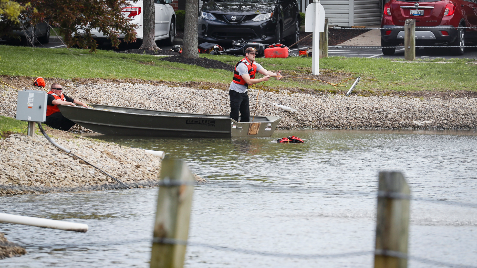 Police authorities search a nearby pond at a scene at an apartment complex Monday, April 29, 2019, in West Chester, Ohio. Several people were found dead at the apartment complex where multiple gunshots were fired, police said Monday. No suspect has been identified. (AP Photo/John Minchillo)