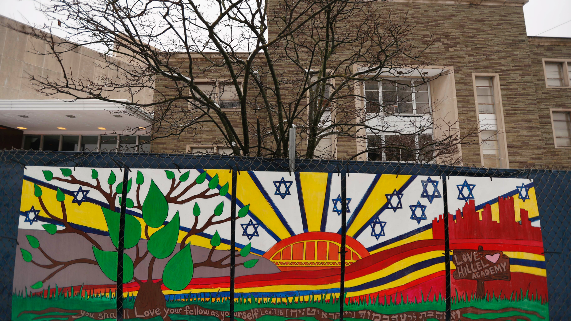 FILE--This file photo from Feb. 11, 2019 shows artwork on a fence around the Tree of Life Synagogue in Pittsburgh where 11 people were killed and seven others injured during an attack on in October of 2018. The synagogue is inviting young people worldwide to submit artwork in an art project called "#HeartsTogether: The Art of Rebuilding." to cover more of the fencing that surrounds the still-shuttered building. They are looking for "original, uplifting images and graphics" to be printed on windscreens that will cover the temporary perimeter fencing. (AP Photo/Keith Srakocic, File)