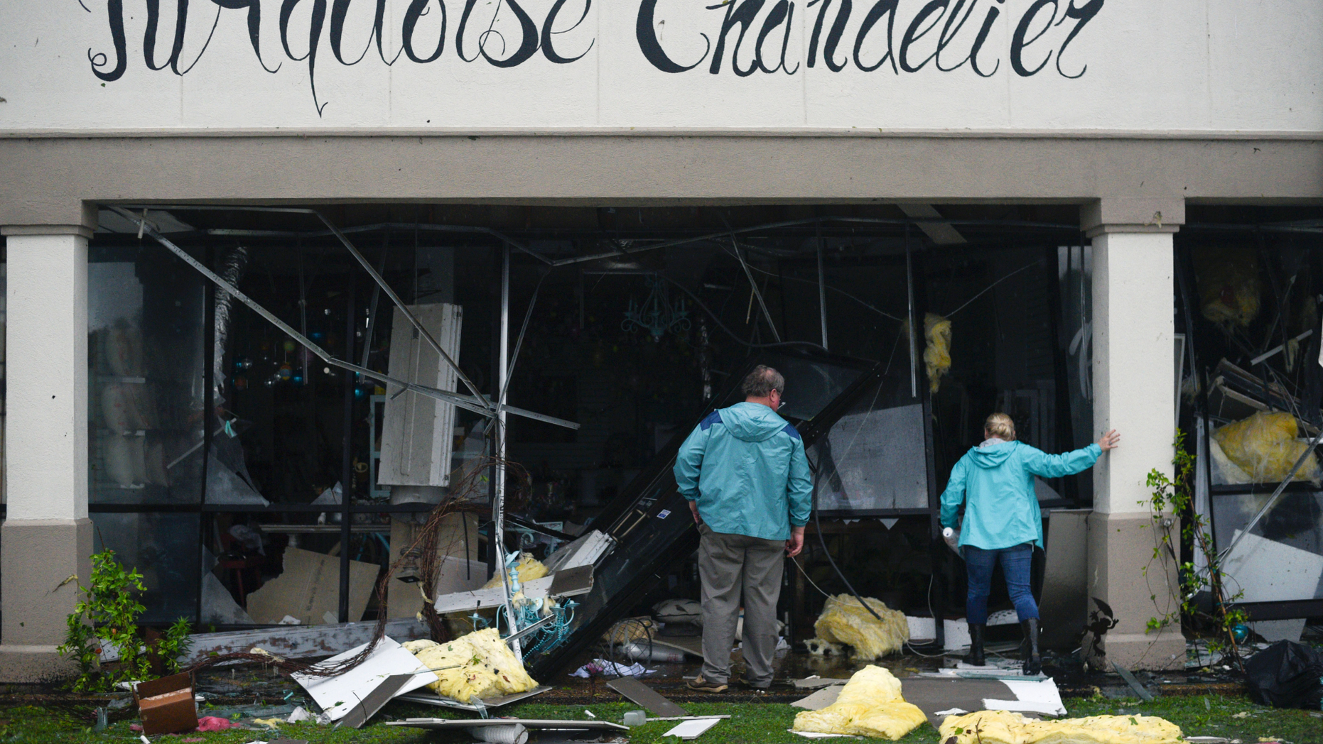 Robert and Marion Murphy peek into their damaged shop in the Pemberton Quarters strip mall following severe weather Saturday, April 13, 2019 in Vicksburg, Miss. Authorities say a possible tornado has touched down in western Mississippi, causing damage to several businesses and vehicles. John Moore, a forecaster with the National Weather Service in Jackson, says a twister was reported Saturday in the Vicksburg area of Mississippi and was indicated on radar. (Courtland Wells/The Vicksburg Post via AP)