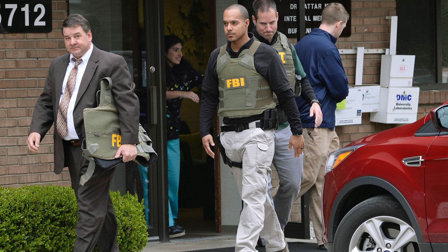 FILE - In this April 21, 2017 file photo, FBI agents leave the office of Dr. Fakhruddin Attar at the Burhani Clinic in Livonia, Mich., after completing a search for documents. The U.S. Justice Department won't appeal a decision by a Detroit federal judge who threw out female genital mutilation charges against members of a Muslim sect. On Wednesday, April 11, 2019 Solicitor General Noel Francisco calls it an "especially heinous practice" but said the law needs to be changed to mesh with U.S. Supreme Court precedent. Judge Bernard Friedman in November said the law was unconstitutional because Congress didn't have power to regulate genital mutilation. (Clarence Tabb Jr. /Detroit News via AP, File)