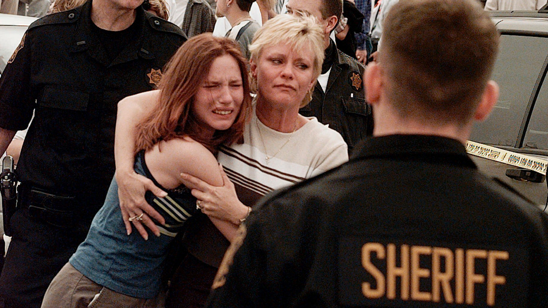 FILE - In this April, 20, 1999, file photo, a woman embraces her daughter after they were reunited following a shooting at Columbine High School in Littleton, Colo. The shooting shocked the country as it played out on TV news shows from coast to coast. Images from the scene showed terrified students fleeing the school, SWAT officers waiting to enter and an injured boy trying to escape through a window. (AP Photo/Ed Andrieski, File)