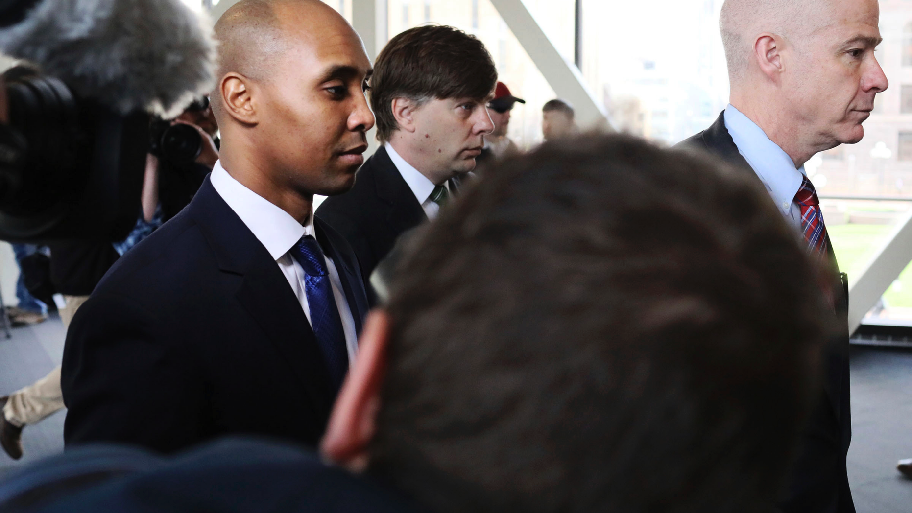 Former Minneapolis police officer Mohamed Noor, center, is accompanied by his attorneys Peter Wold, not pictured, and Thomas Plunkett, right, as he walks towards the Hennepin County Government Center for opening arguments of his trial Tuesday, April 9, 2019, in Minneapolis, Minn. Opening arguments scheduled to begin in the trial of former Minneapolis police officer Mohamed Noor in the shooting death of Justine Ruszczyk Damond. (David Joles/Star Tribune via AP)