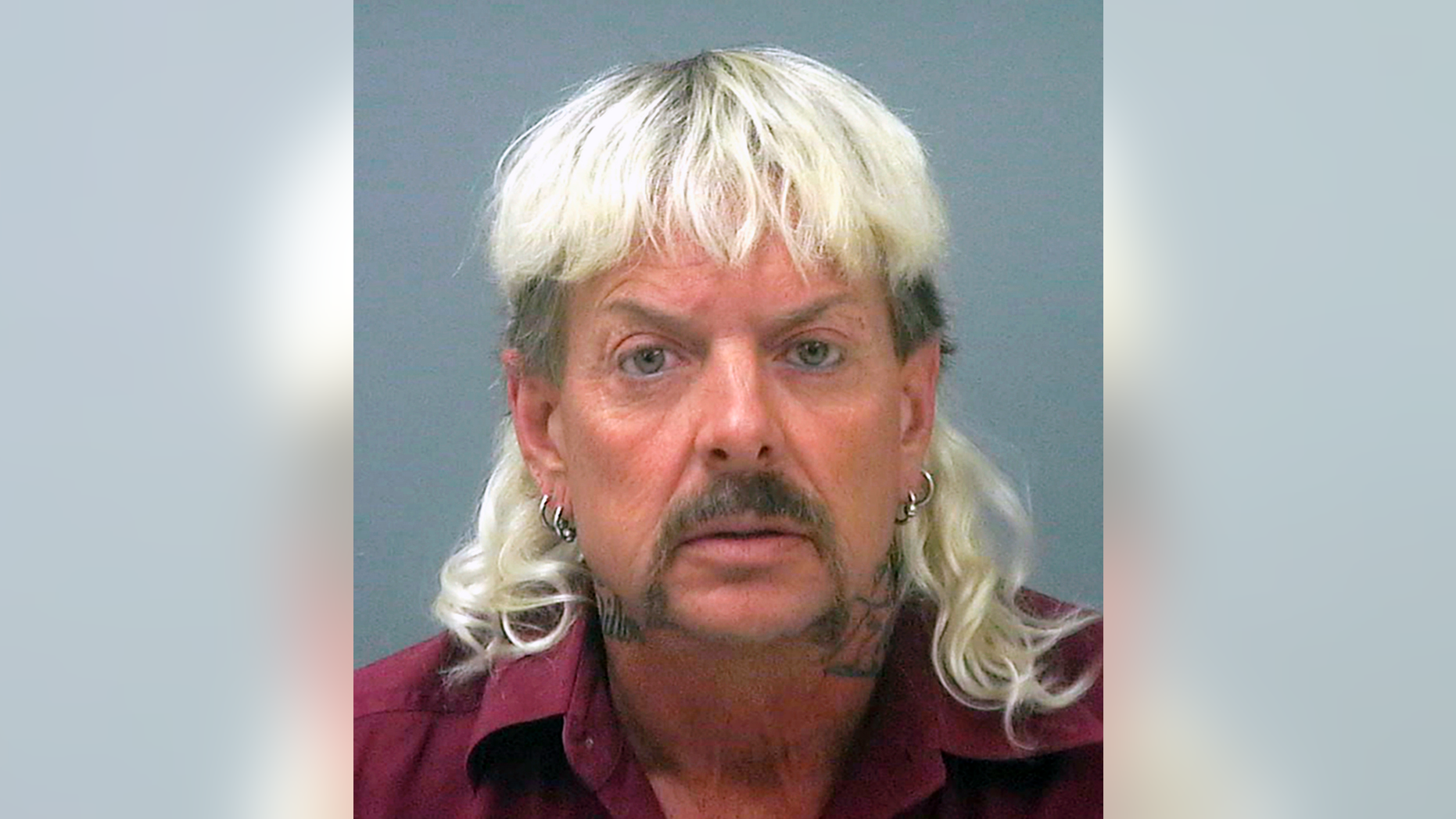 FILE - This file photo provided by the Santa Rose County Jail in Milton, Fla., shows Joseph Maldonado-Passage. Prosecutors say Maldonado-Passage, also known as "Joe Exotic, tried to arrange the killing of Carole Baskin, the founder of Big Cat Rescue. Lurors were shown a Facebook video Tuesday, March 26, 2019, that depicts Maldonado-Passage shooting a blow-up "Carole" doll in the head. Other videos show him pretending to dig a grave for Baskin and threatening to mail her rattlesnakes. (Santa Rosa County Jail via AP, File)