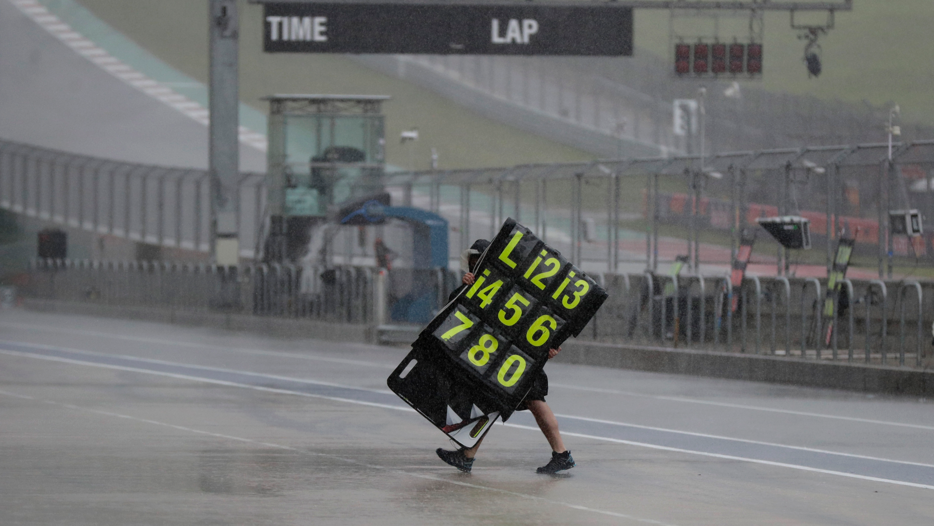 A crew member moves the traffic signs during a time delay for testing and qualifying for the motorcycle race of the Grand Prix of the Americas on the Circuit of the Americas on Saturday, April 13, 2019, in Austin, Texas. (AP Photo / Eric Gay)