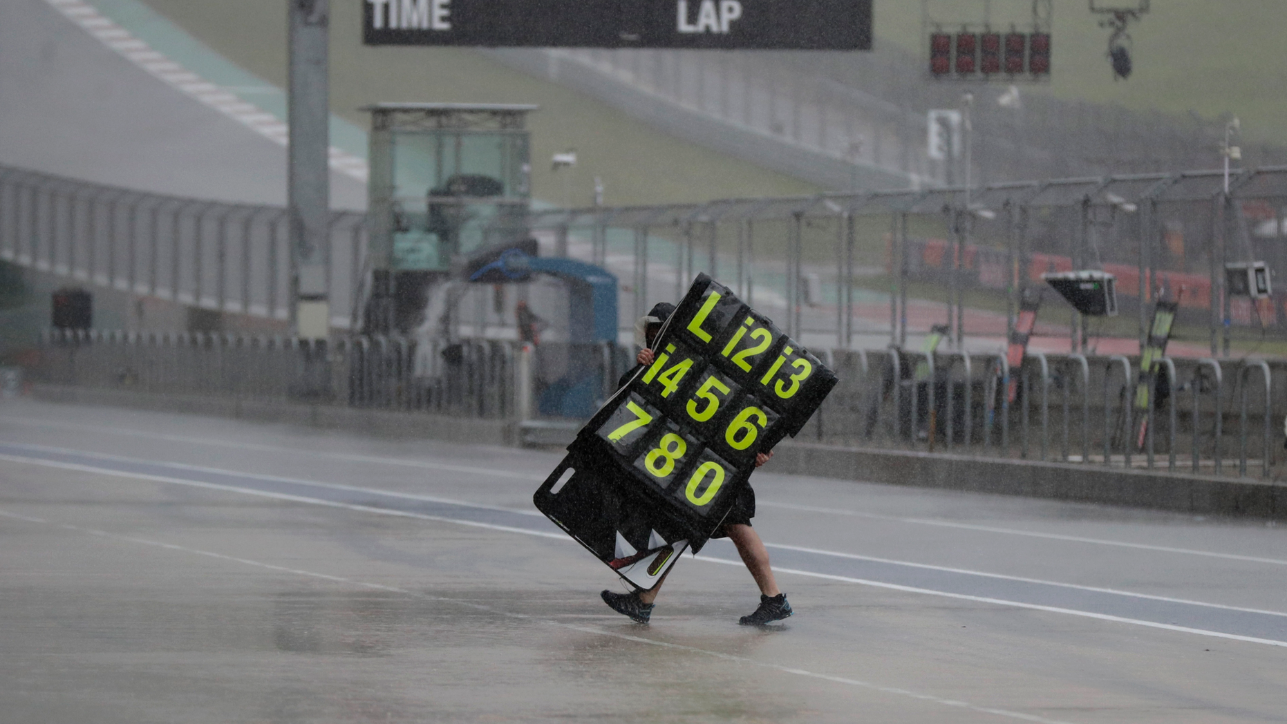 A crew member moves the traffic signs during a time delay for testing and qualifying for the motorcycle race of the Grand Prix of the Americas on the Circuit of the Americas on Saturday, April 13, 2019, in Austin, Texas. (AP Photo / Eric Gay)