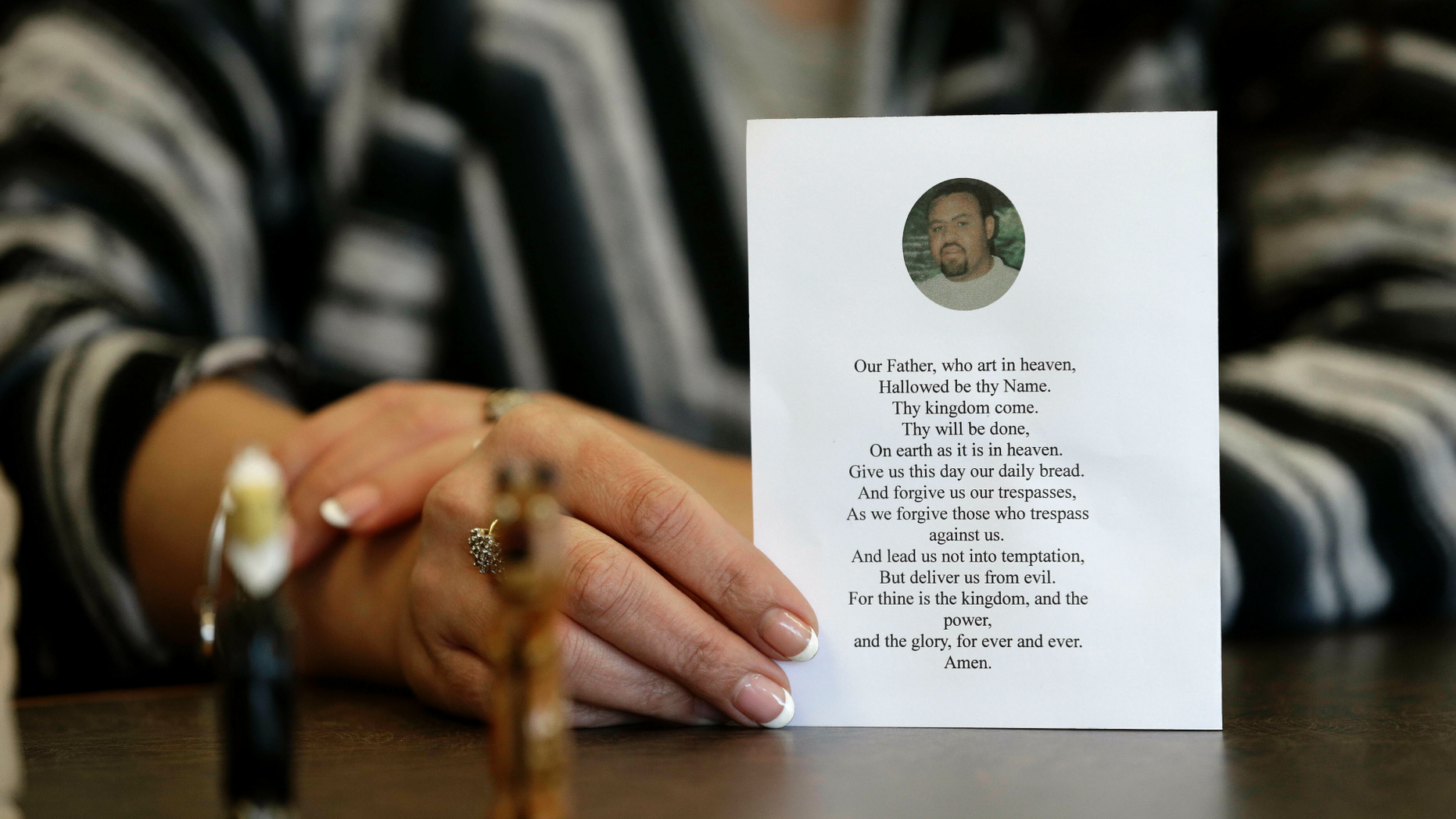 In this photo taken Wednesday, March 6, 2019 in Raleigh, N.C. Heather Allen holds a photo of her father, Lee Wayne Hunt, from his memorial. Even though Lee Wayne Hunt died as a prisoner found guilty of a double murder, his family says he never gave up hope of proving his innocence. (AP Photo/Gerry Broome)
