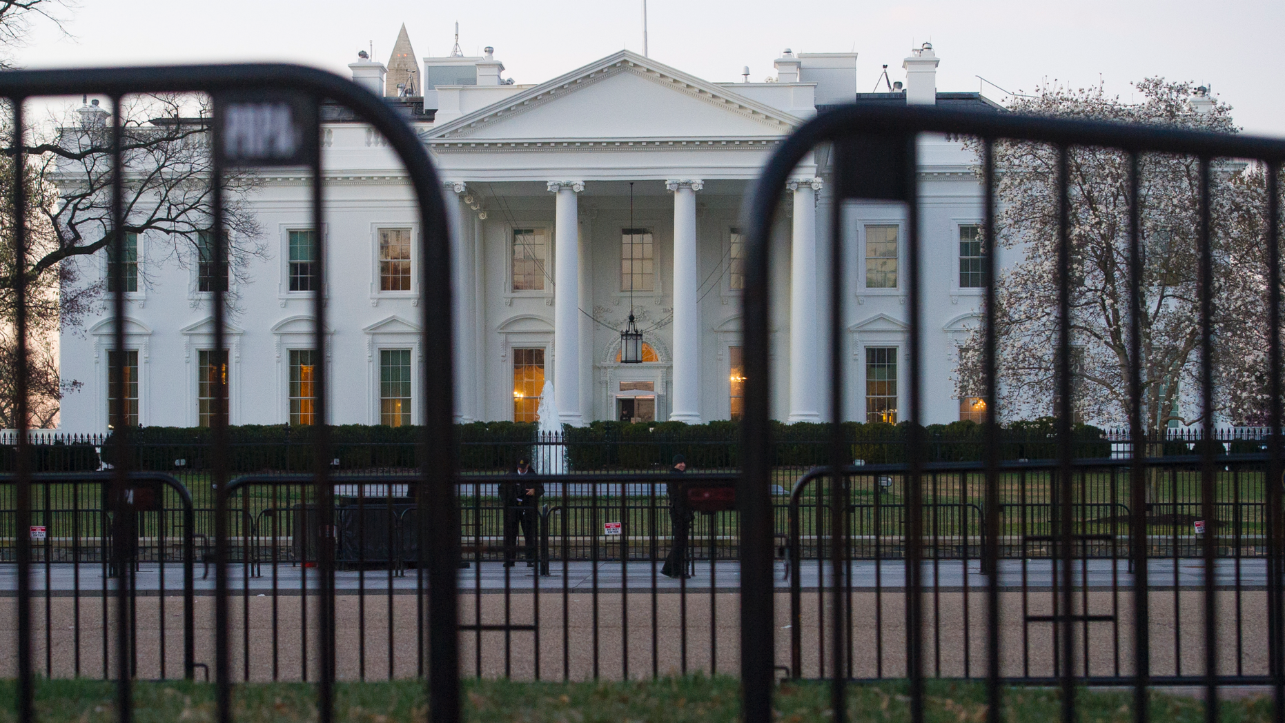 The White House is seen behind security barriers in Washington. A White House official turned whistleblower says dozens of people in President Donald Trump’s administration were granted access to classified information desp