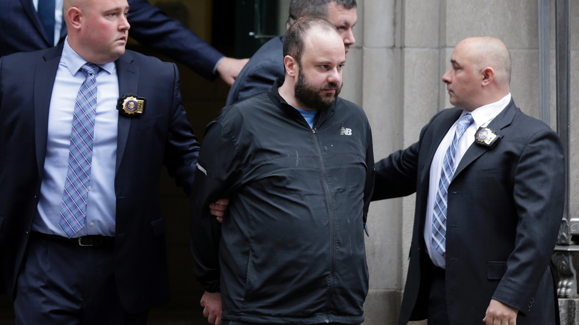 Marc Lamparello, 37, center, is escorted out of a police precinct in New York, Thursday, April 18, 2019. Police say Lamparello was arrested after entering St. Patrick's Cathedral last week in New York with two cans of gasoline, lighter fluid and butane lighters. Lamparello made his initial court appearance from a hospital. The judge ordered him to undergo a psychiatric evaluation. (AP Photo/Seth Wenig)