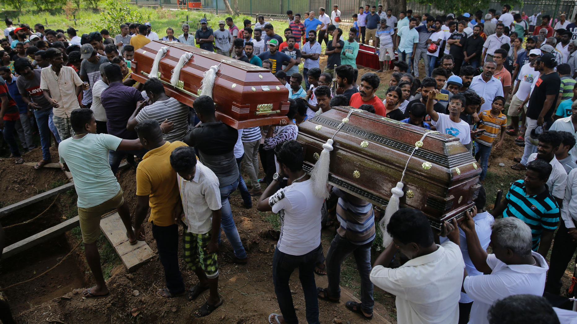 FILE - In this Tuesday, April 23, 2019, file photo, Sri Lankans carry the coffins carrying victims of the Easter Sunday bombings in Colombo, Sri Lanka. The U.S. ambassador says America had "no prior knowledge" of a threat in Sri Lanka before the Easter bombings that killed more than 350 people. (AP Photo/Eranga Jayawardena, File)
