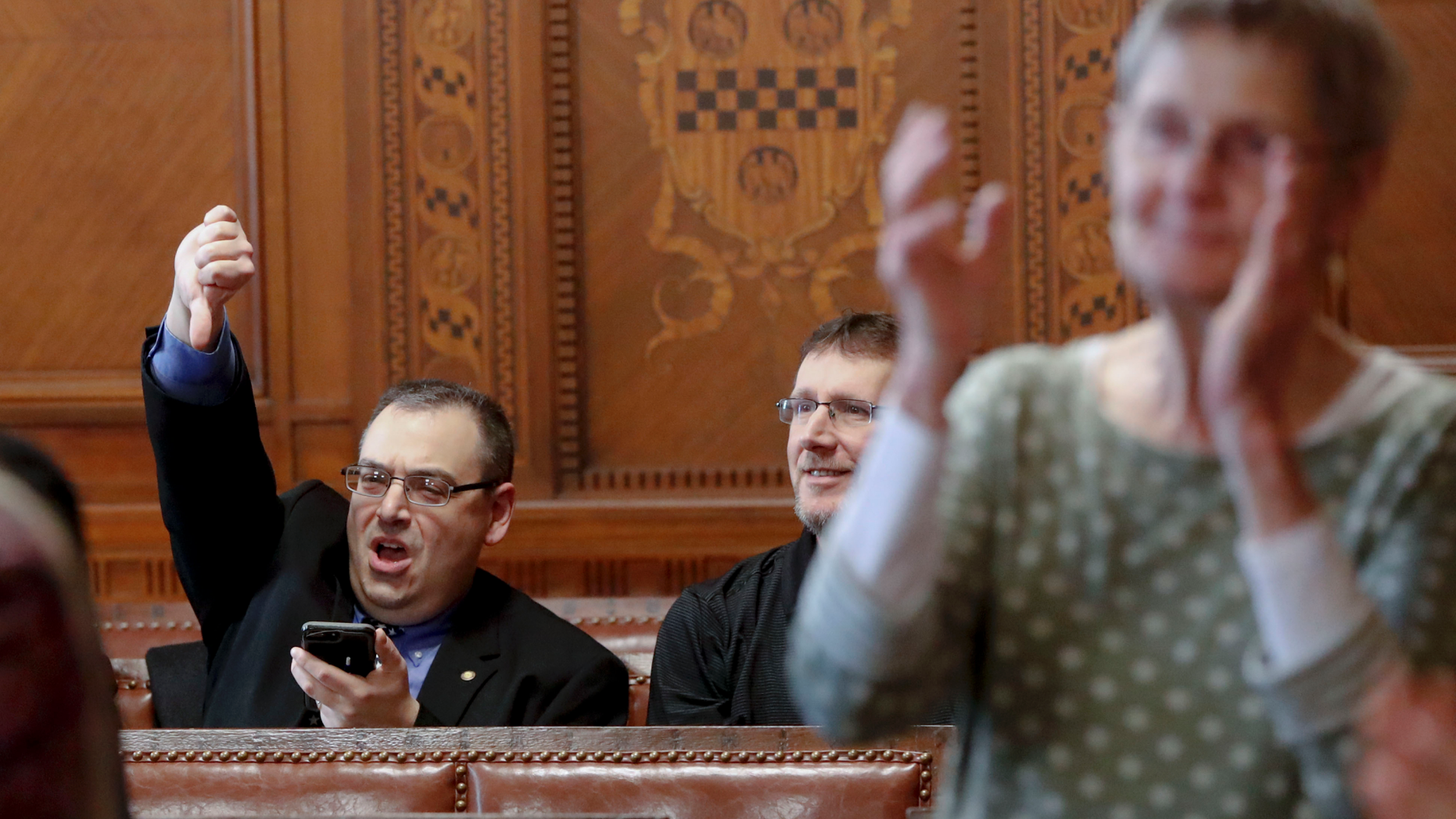 Val Finnell, left, gives a thumbs down, as other applaud after the Pittsburgh City Council voted 6-3 to pass gun-control legislation, Tuesday, April 2, 2019, in Pittsburgh. The bill, introduced in the wake of the synagogue massacre last October, places restrictions on military-style assault weapons like the AR-15 rifle that authorities say was used in the attack that killed 11 and wounded seven. (AP Photo/Keith Srakocic)