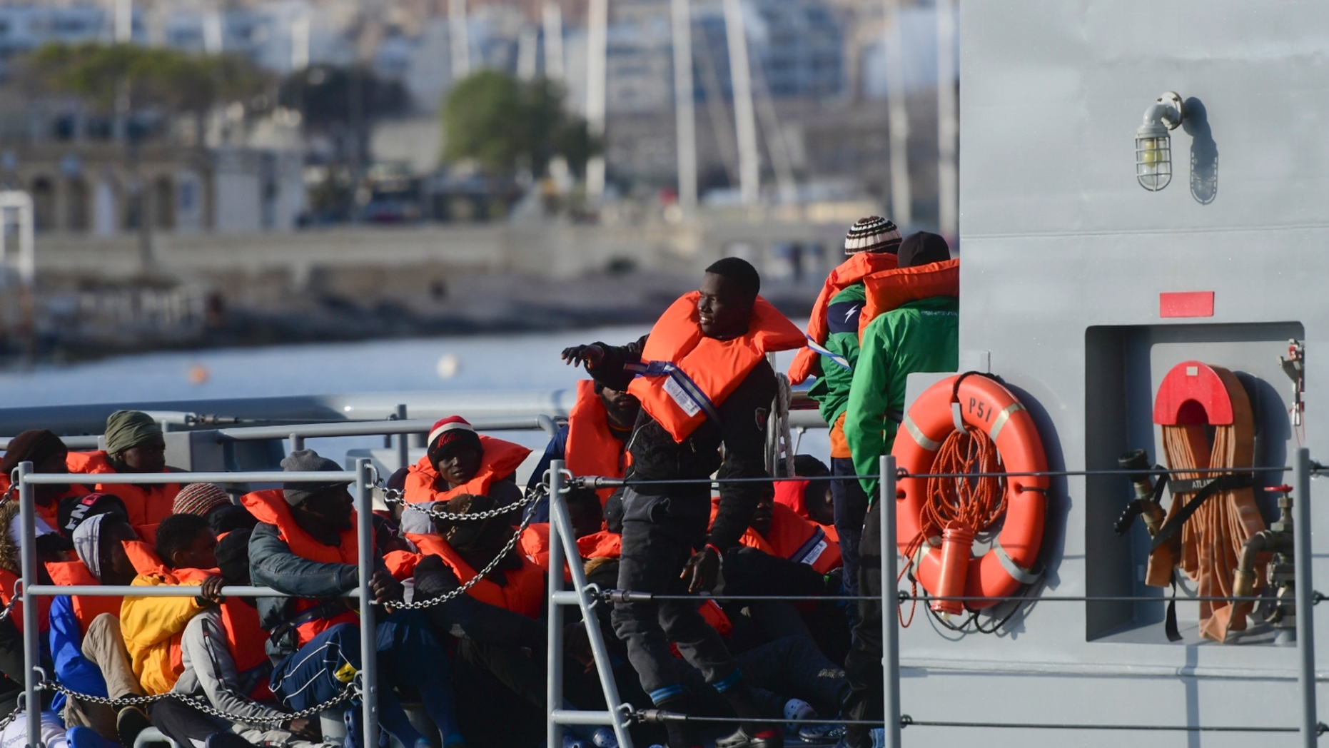 Migrants disembark after being transferred to Maltese army boats at sea and brought to Valletta harbor, Malta, Saturday, April 13, 2019. Malta has announced a deal that see four European Union nations taking in the 64 migrants rescued at sea off Libya 10 days ago. Malta announced Saturday that the migrants will be distributed among Germany, France, Portugal and Luxembourg. (AP Photo/Jonathan Borg)