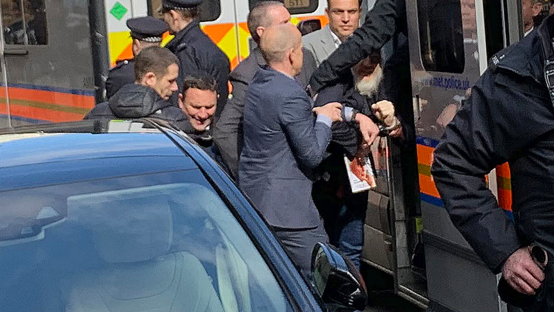 Police bundle WikiLeaks founder Julian Assange from the Ecuadorian embassy into a police van in London after he was arrested by officers from the Metropolitan Police and taken into custody Thursday April 11, 2019. Police in London arrested WikiLeaks founder Assange at the Ecuadorean embassy Thursday for failing to surrender to the court in 2012, shortly after the South American nation revoked his asylum. (@DailyDOOH via AP)