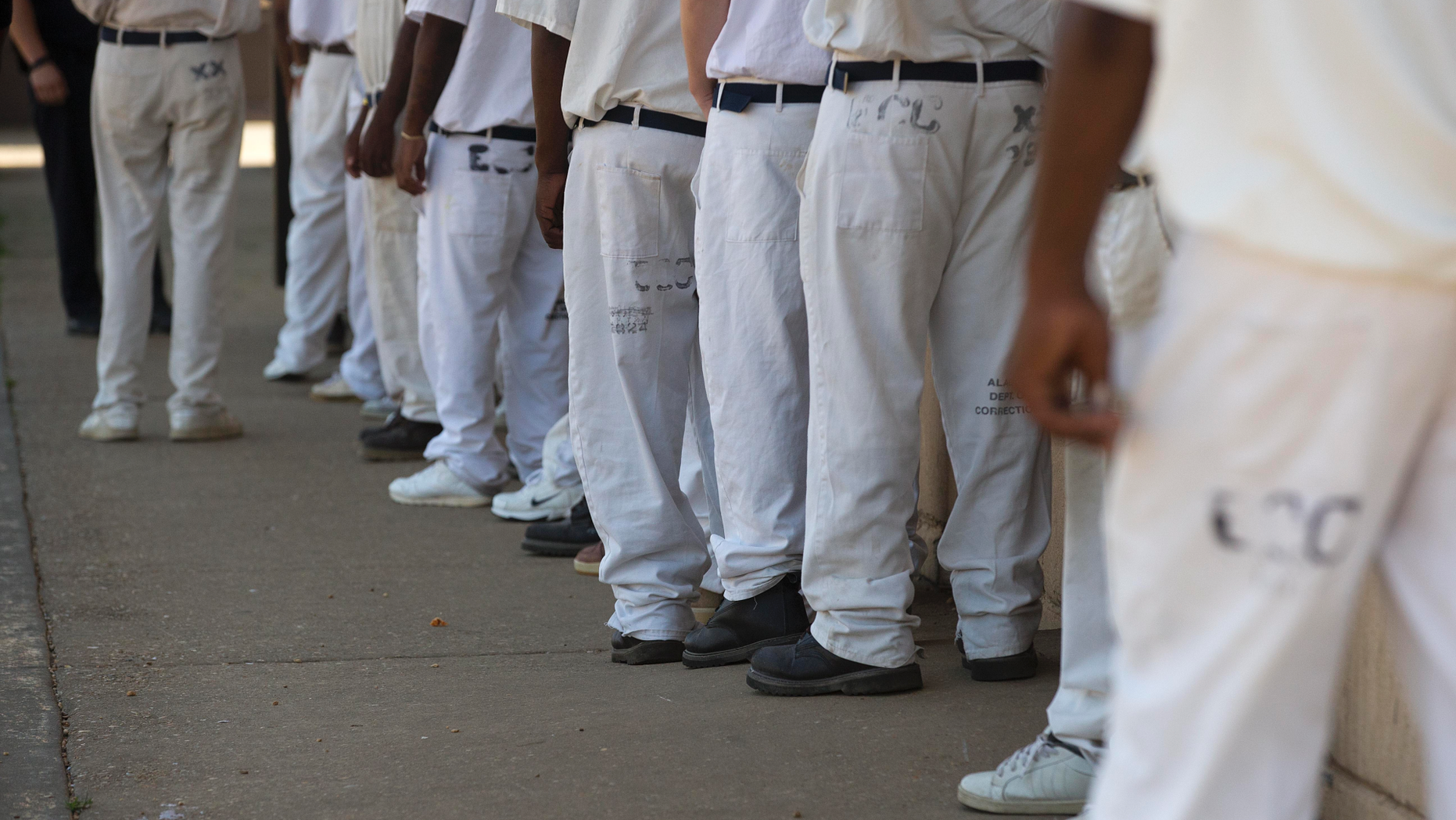 FILE- In this June 18, 2015 file photo, prisoners stand in a crowded lunch line during a prison tour at Elmore Correctional Facility in Elmore, Ala. he Justice Department has determined that Alabama's prisons are violating the Constitution by failing to protect inmates from violence and sexual abuse and by housing them in unsafe and overcrowded facilities, according to a scathing report Wednesda, April 3, 2019, that described the problems as "severe" and "systemic.". (AP Photo/Brynn Anderson)