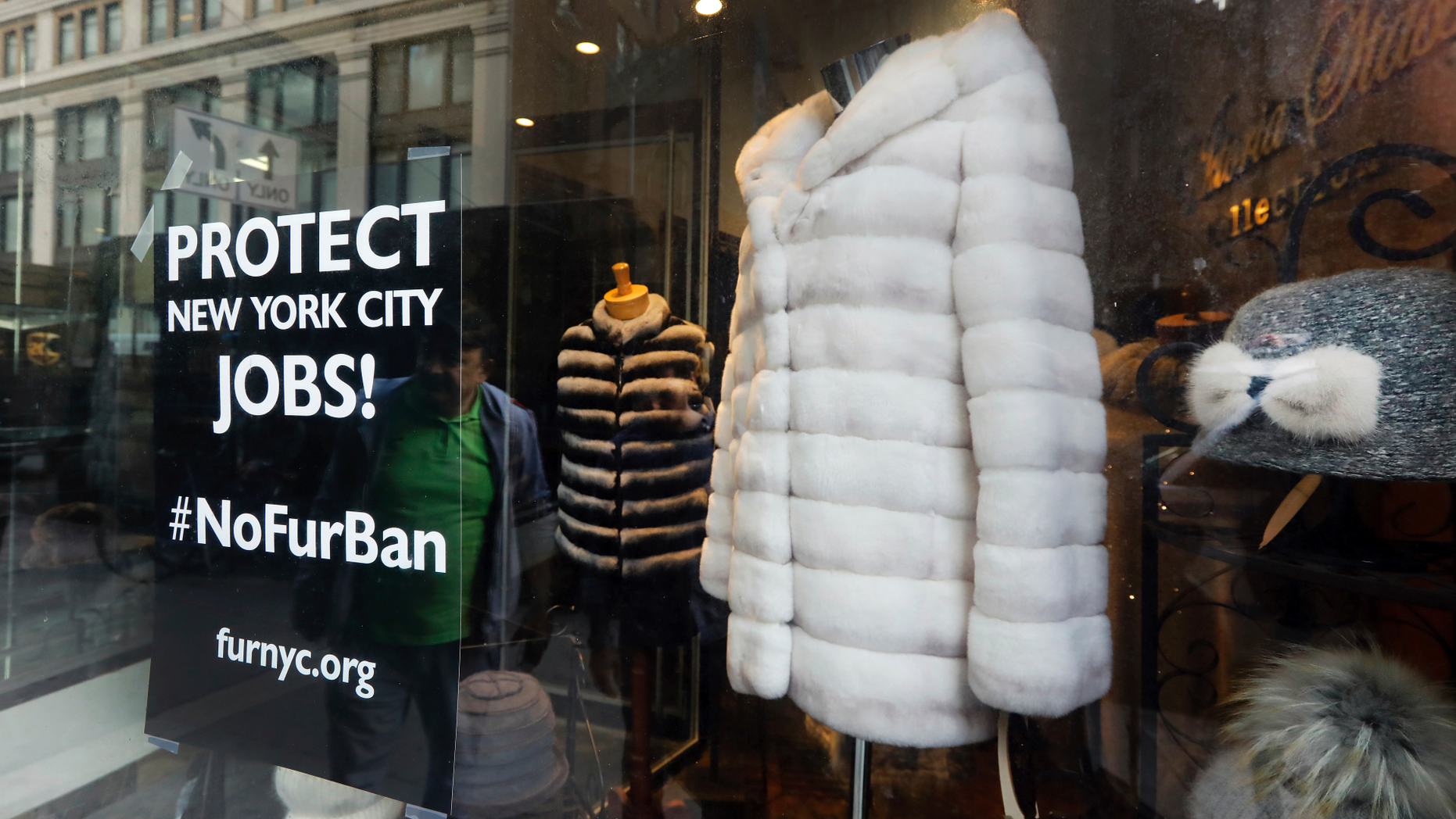 This April 10, 2019, photo shows a sign by furnyc.org in the window of Victoria Stass Collection in New York's fur district. The fur trade is considered so important to New York’s development that two beavers adorn the city’s official seal, a reference to early Dutch and English settlers who traded in beaver pelts. (AP Photo/Richard Drew)