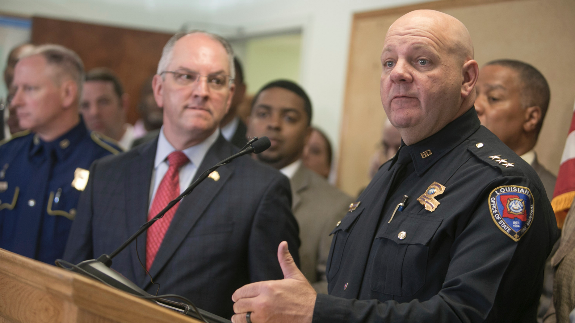 Louisiana State Fire Marshal H. "Butch" Browning speaks as Louisiana Gov. John Bel Edwards looks on during a press conference on the arrest of a suspect Holden Matthews for the arson of three churches in Opelousas, La., Thursday, April 11, 2019. (AP Photo/Lee Celano)