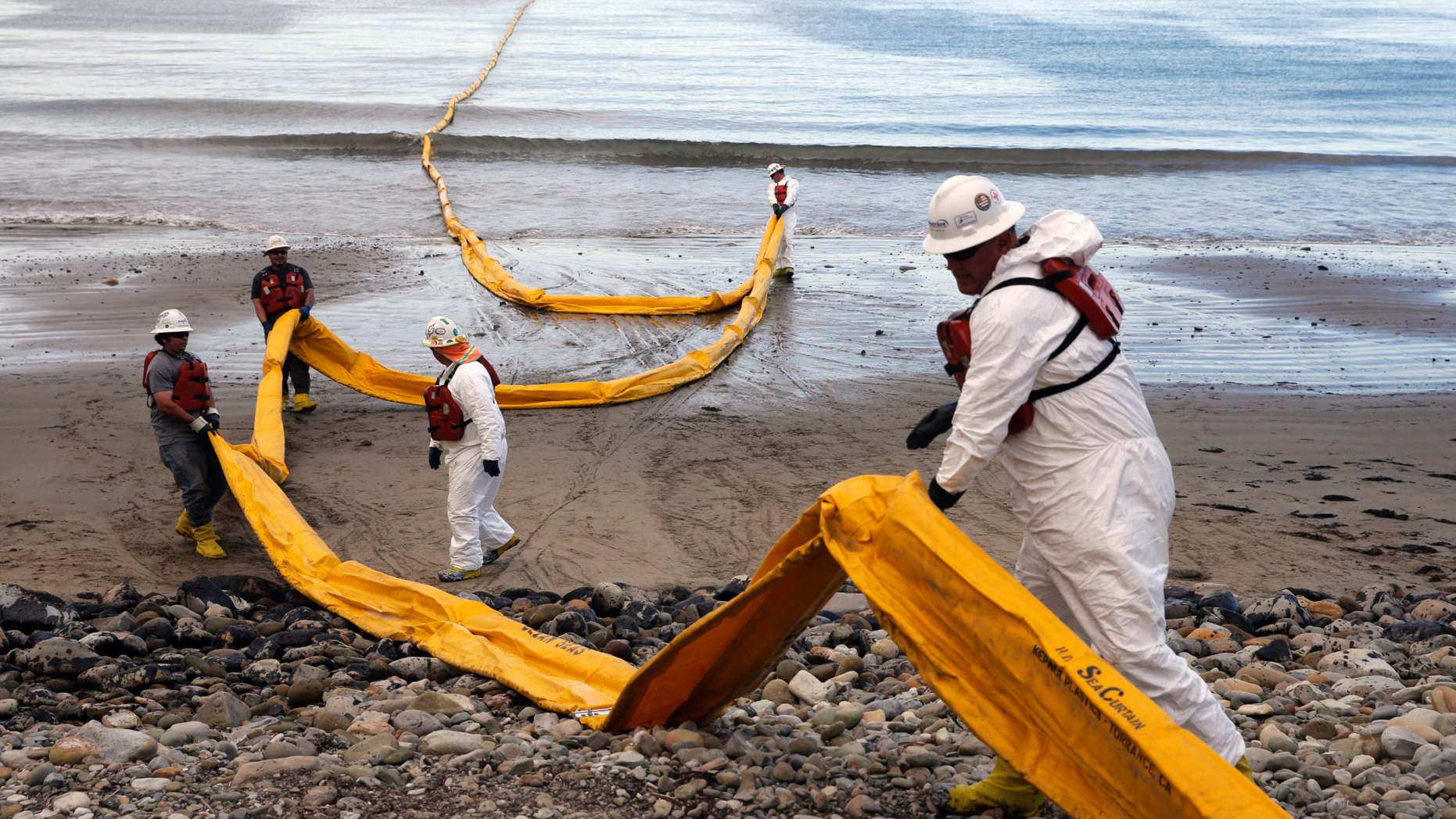 FILE - In this May 21, 2015, file photo, workers prepare an oil containment boom at Refugio State Beach, north of Goleta, Calif., two days after an oil pipeline ruptured, polluting beaches and killing hundreds of birds and marine mammals. A company that caused the worst California coastal oil spill in 25 years has been fined more than $3.3 million. A judge in Santa Barbara issued the fine and penalty Thursday, April 25, 2019, against Houston-based Plains All American Pipeline. Additional damages could be levied at a restitution hearing next month. (AP Photo/Jae C. Hong, File)
