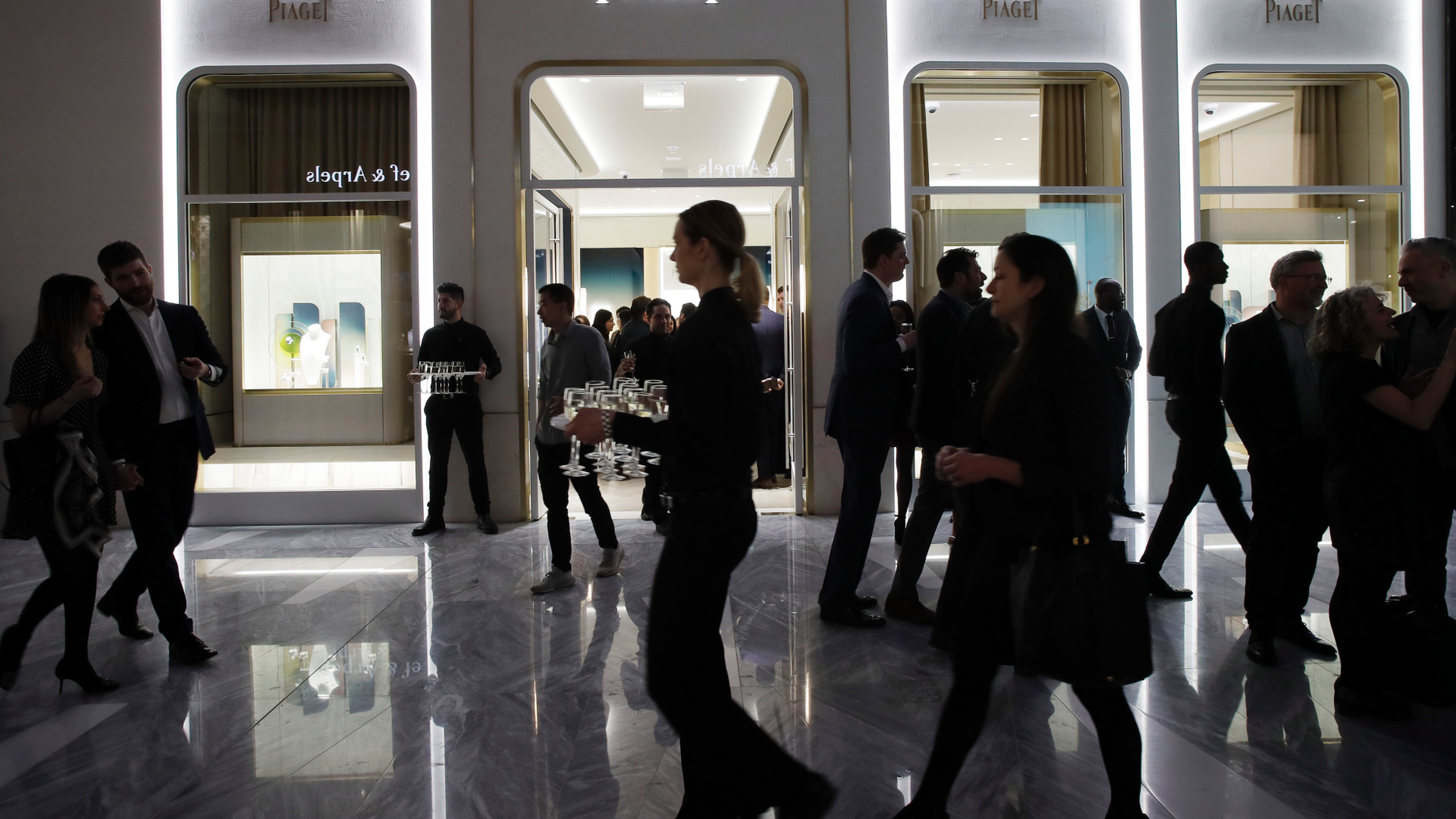FILE- In this March 14, 2019, file photo people attend the opening of a Piaget store during the opening night of The Shops & Restaurants at Hudson Yards in New York. On Monday, April 1, the Commerce Department releases U.S. retail sales data for February. (AP Photo/Mark Lennihan, File)