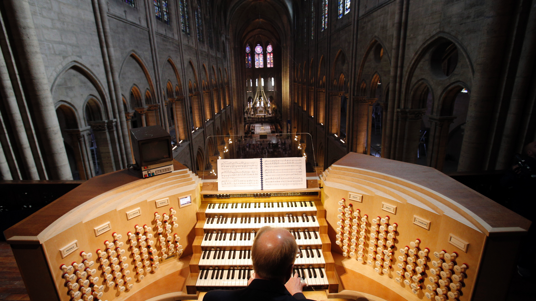 FILE - In this Thursday, May 2, 2013 file photo, Philippe Lefebvre, 64, plays the organ at Notre Dame cathedral in Paris. (AP Photo/Christophe Ena, file)