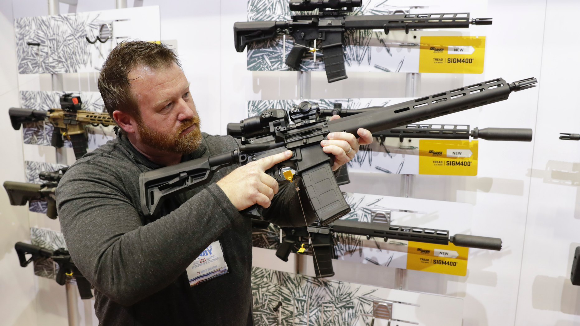 Bryan Oberc, Munster, Ind., tries out an AR-15 from Sig Sauer in the exhibition hall at the National Rifle Association Annual Meeting in Indianapolis, Saturday, April 27, 2019. (AP Photo/Michael Conroy)