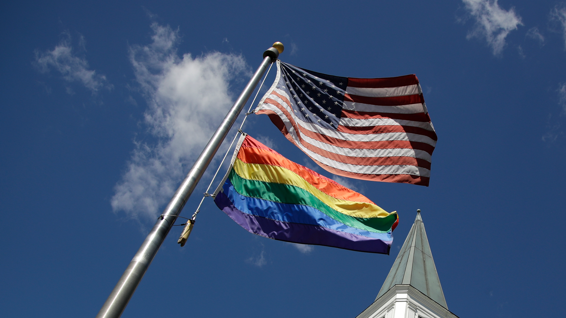 A gay pride rainbow flag flies along with the U.S. flag in front of the Asbury United Methodist Church in Prairie Village, Kan., on Friday, April 19, 2019. There's at least one area of agreement among conservative, centrist and liberal leaders in the United Methodist Church: America's largest mainline Protestant denomination is on a path toward likely breakup over differences on same-sex marriage and ordination of LGBT pastors. (AP Photo/Charlie Riedel)