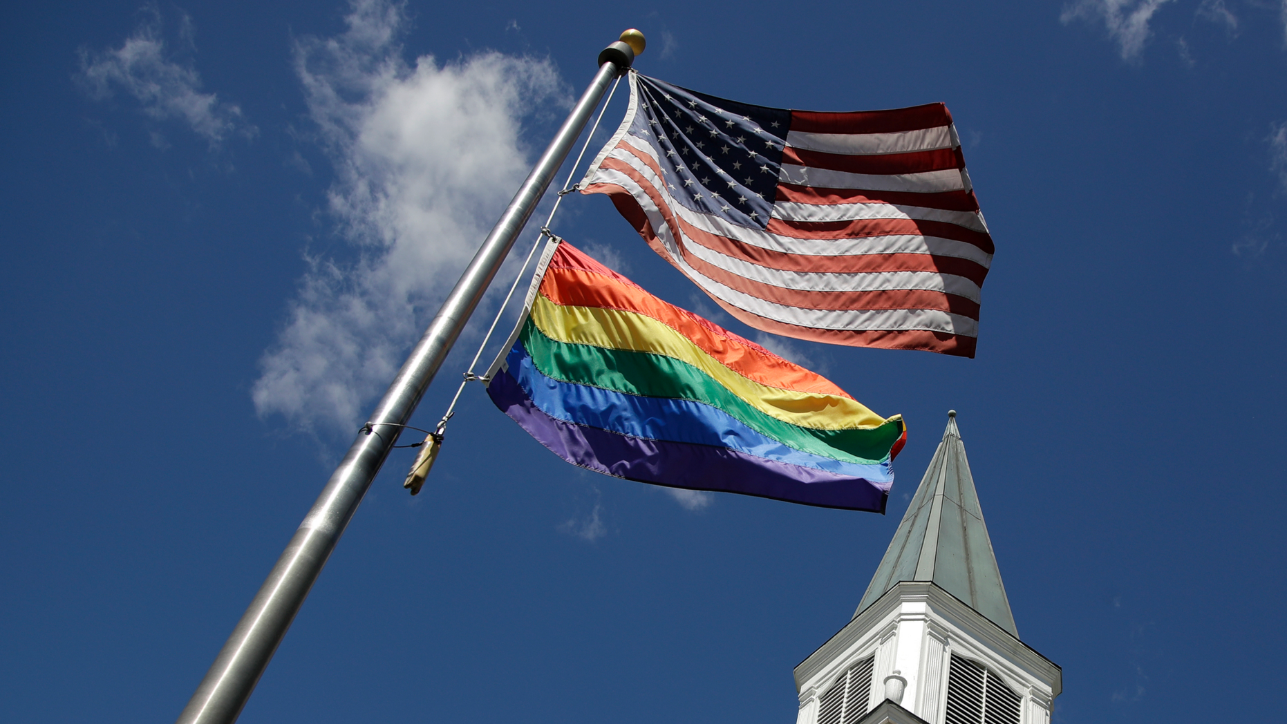 A gay pride rainbow flag flies along with the U.S. flag in front of the Asbury United Methodist Church in Prairie Village, Kan., on Friday, April 19, 2019. There's at least one area of agreement among conservative, centrist and liberal leaders in the United Methodist Church: America's largest mainline Protestant denomination is on a path toward likely breakup over differences on same-sex marriage and ordination of LGBT pastors. (AP Photo/Charlie Riedel)